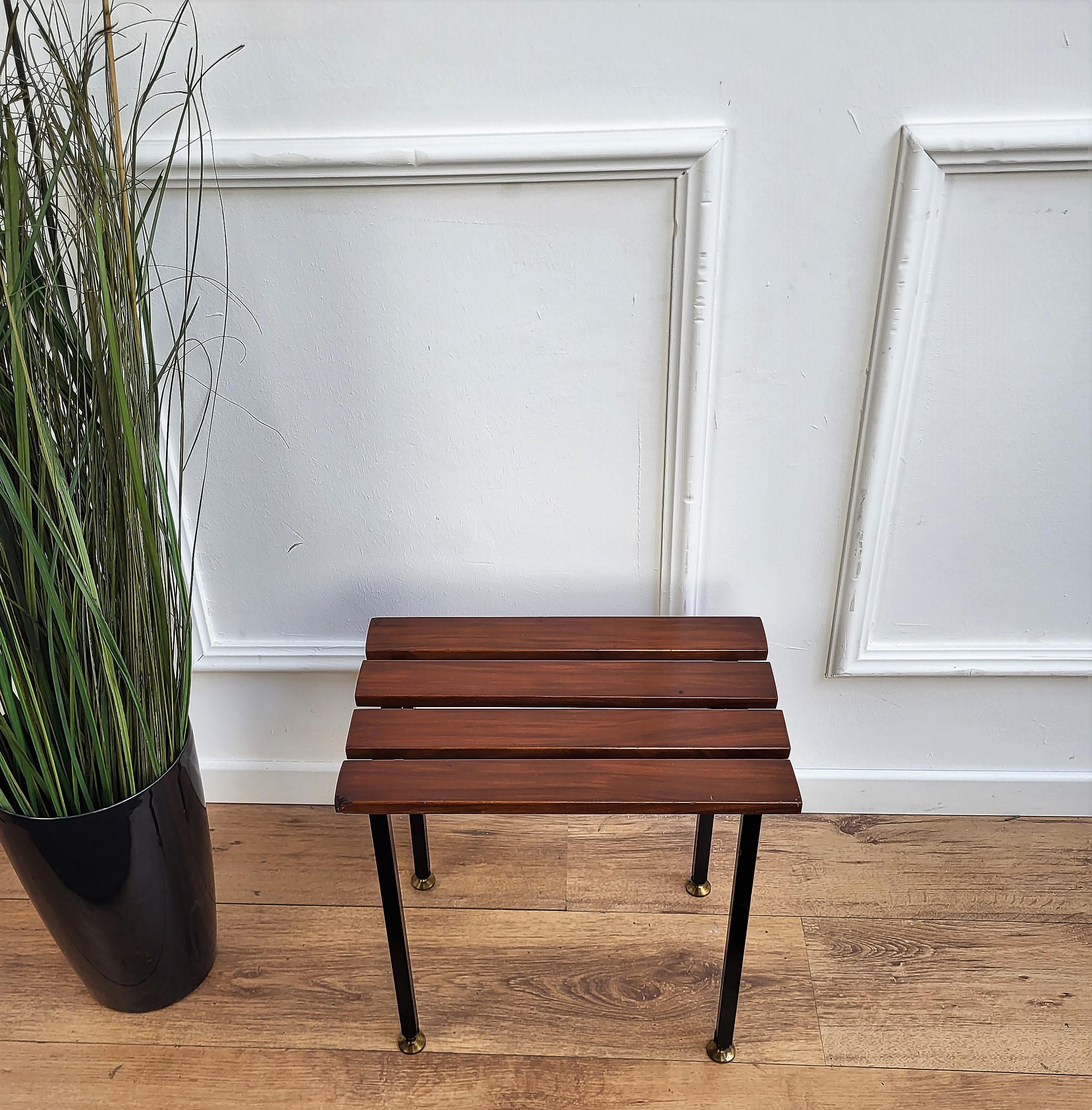 Italian Mid-Century Modern platform slat bench stool with wood slated top sitting on black metal base and nice brass foot-ends. This beautiful side piece can be used as a coffee table.
