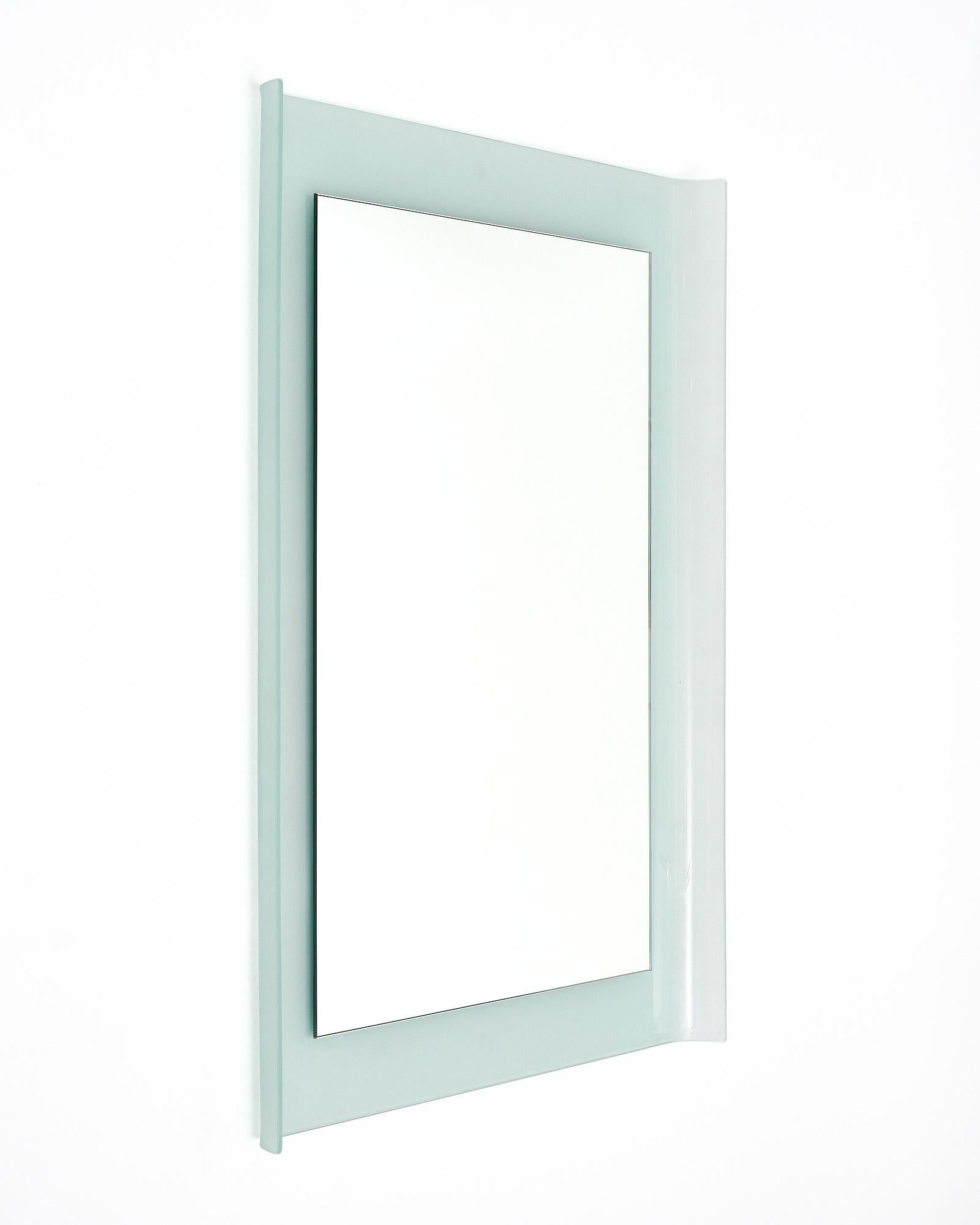 Mirror from Italy in the mid-century style. The rectangular mirror is positioned atop a piece of frosted aquamarine glass with curved sides. We were drawn to the lines of this unique piece.

