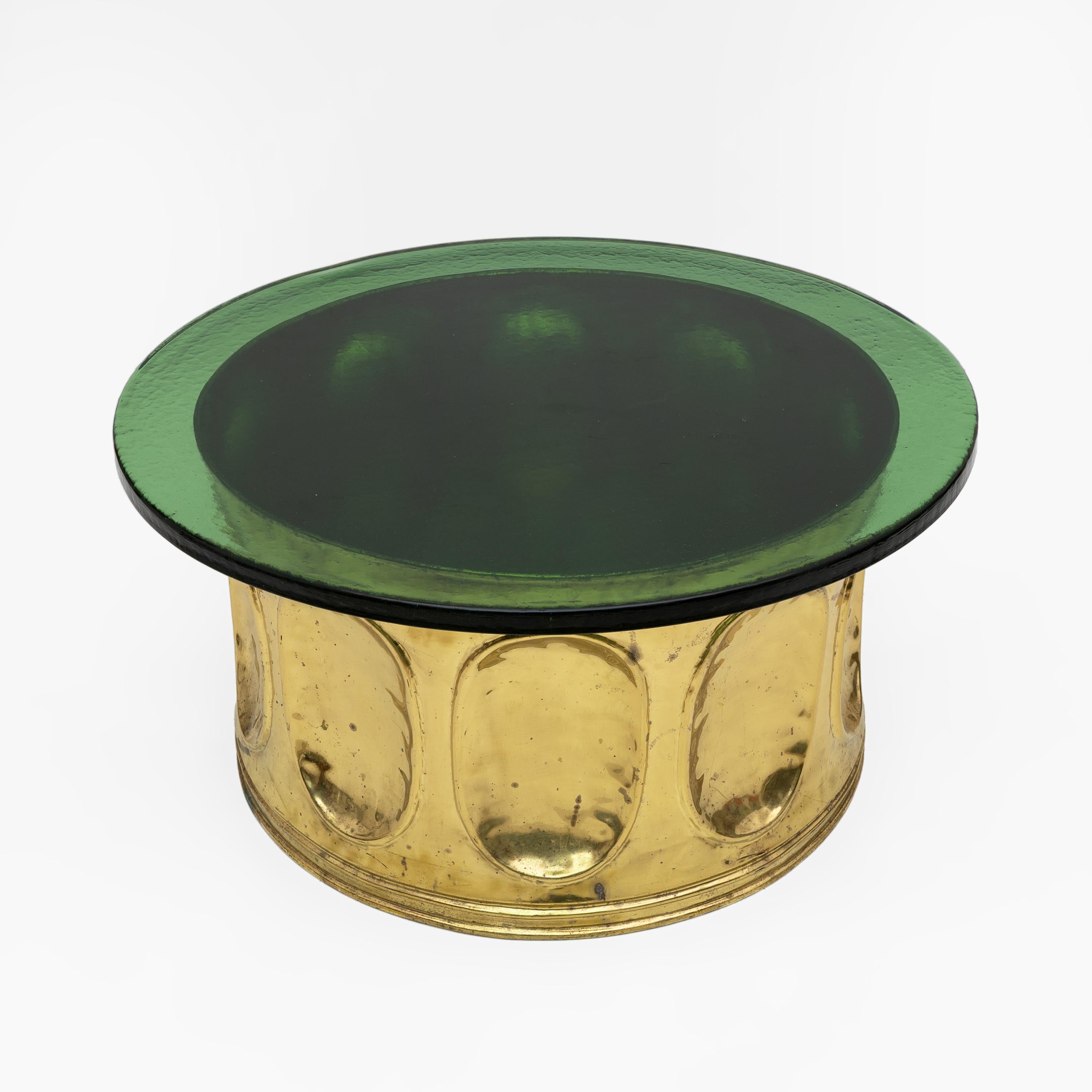 Table basse italienne originale des années 1970. Base circulaire en laiton martelé, plateau en verre soufflé de Murano vert gaufré de 2 cm d'épaisseur. Une pièce unique et précieuse.