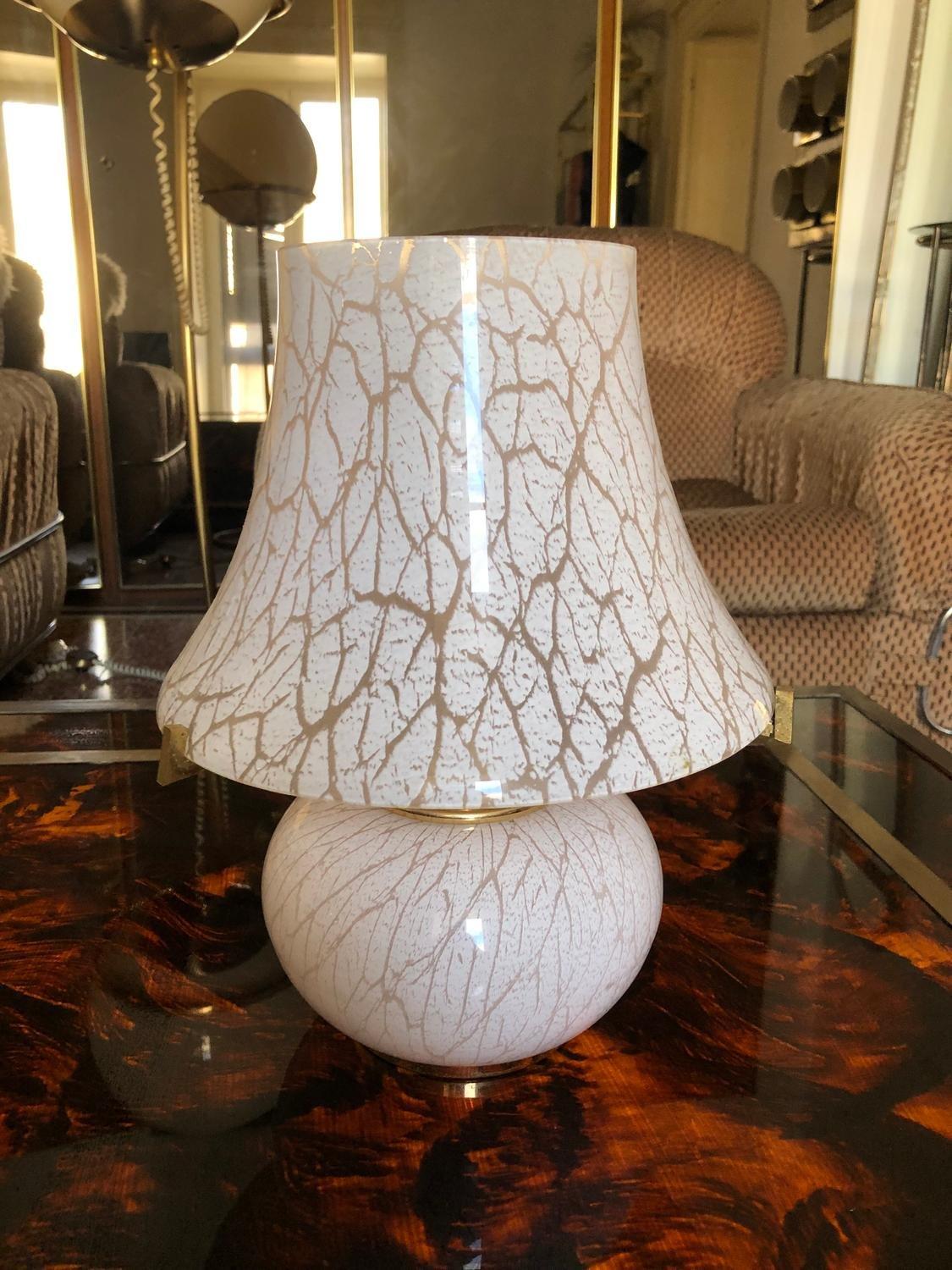 Murano glass mushroom table light. The glass is light pink with camouflage pattern. A beautiful brass stand holds up the lampshade.
Details
Creator: Murano
Dimensions: Height: 32cm Diameter: 26cm
Materials and Techniques: Glass and brass
Place of