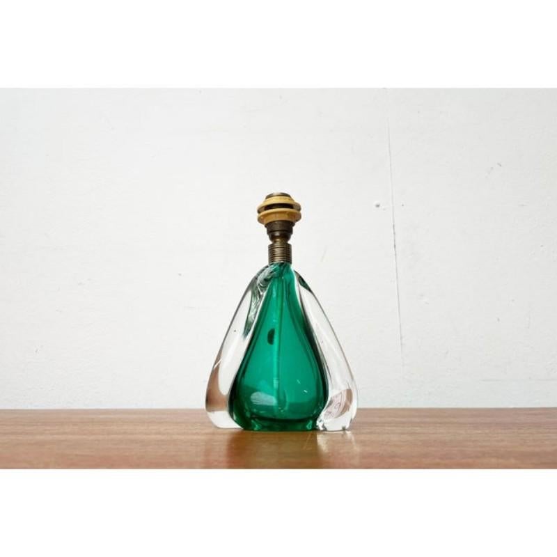Mid-Century glass table lamp from Italy.

A classic Italian design. The base is made of glass. The core is hollow and made in transparent green. Elements made of thick clear glass connect on both sides. The shape of the foot describes a slight