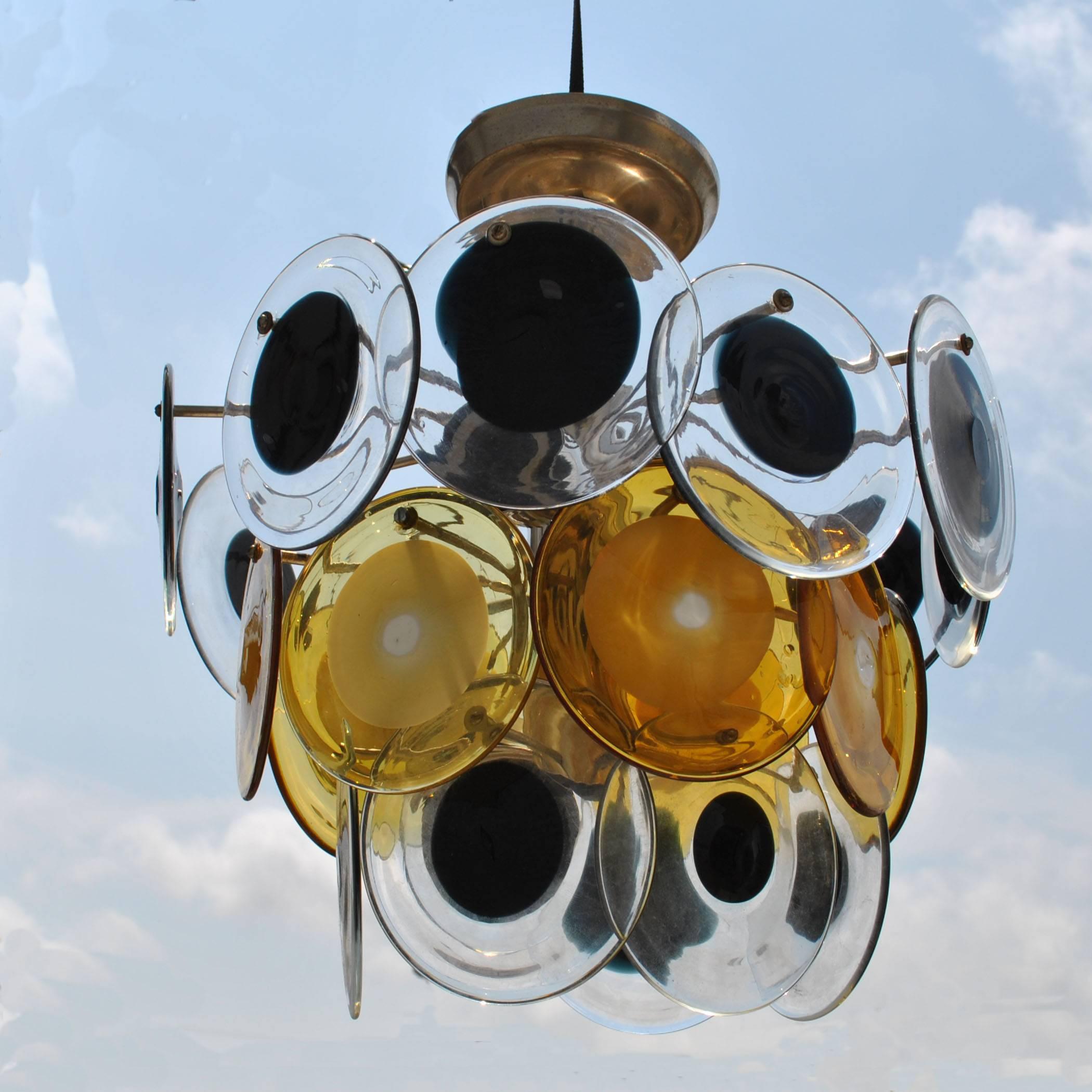 Mid-Century Modern Italian Murano Vistosi glass disc chandelier
circa 1970s 

24 hanging alternating amber and black glass disks on chrome base. A great example of midcentury Italian glass art.