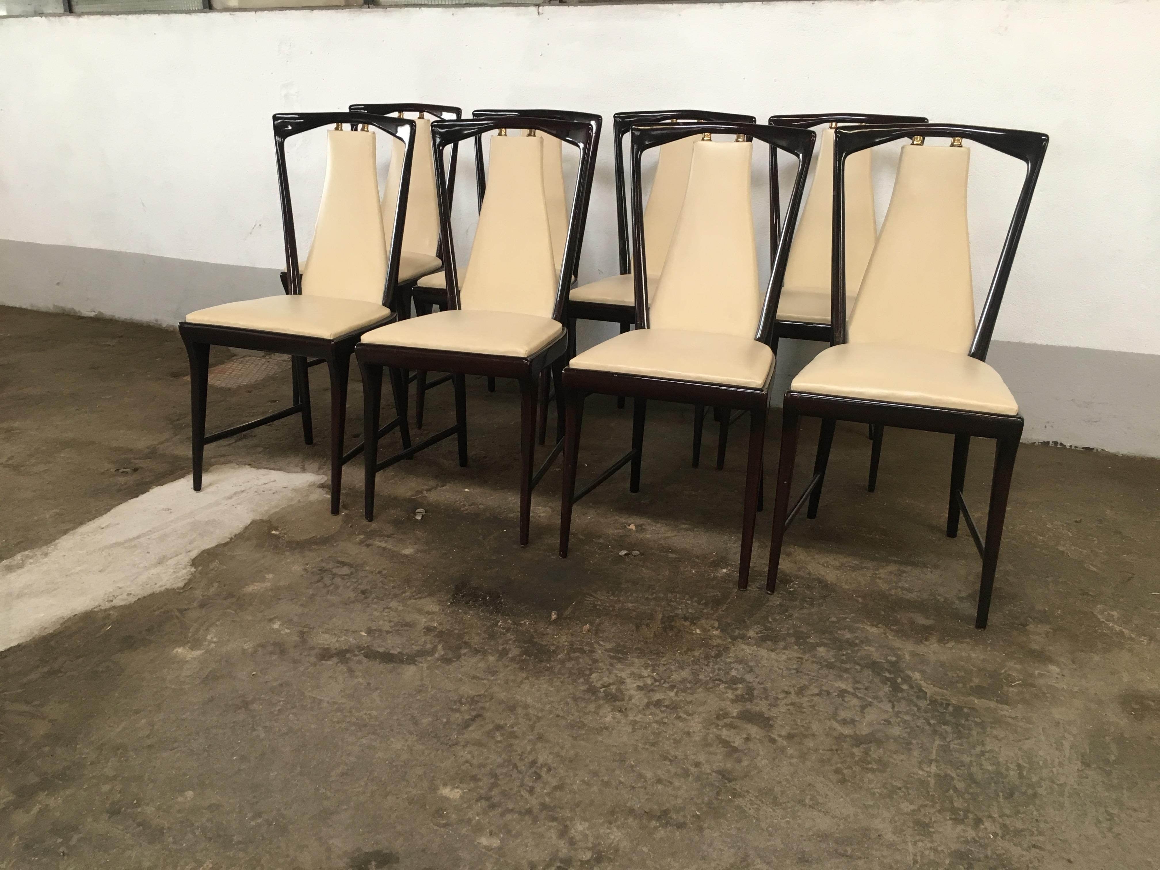 Mid-Century Modern set of 8 Osvaldo Borsani mahogany and faux leather Italian dining chairs with brass details from 1950s
The chairs could be matched with their Dining Table and are a part of a complete dining room set as shown in the photos.
 