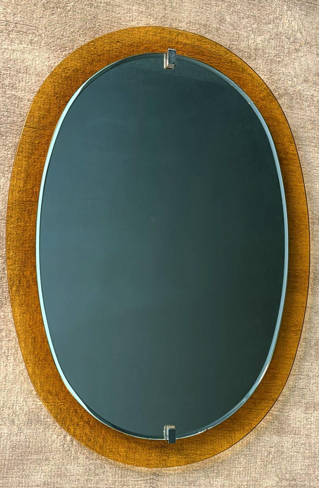 We kindly invite you to read the full description, where we provide detailed technical and historical information to guarantee the authenticity of our items.
Iconic and generously sized beveled oval mirror, mounted with chrome supports on a vivid