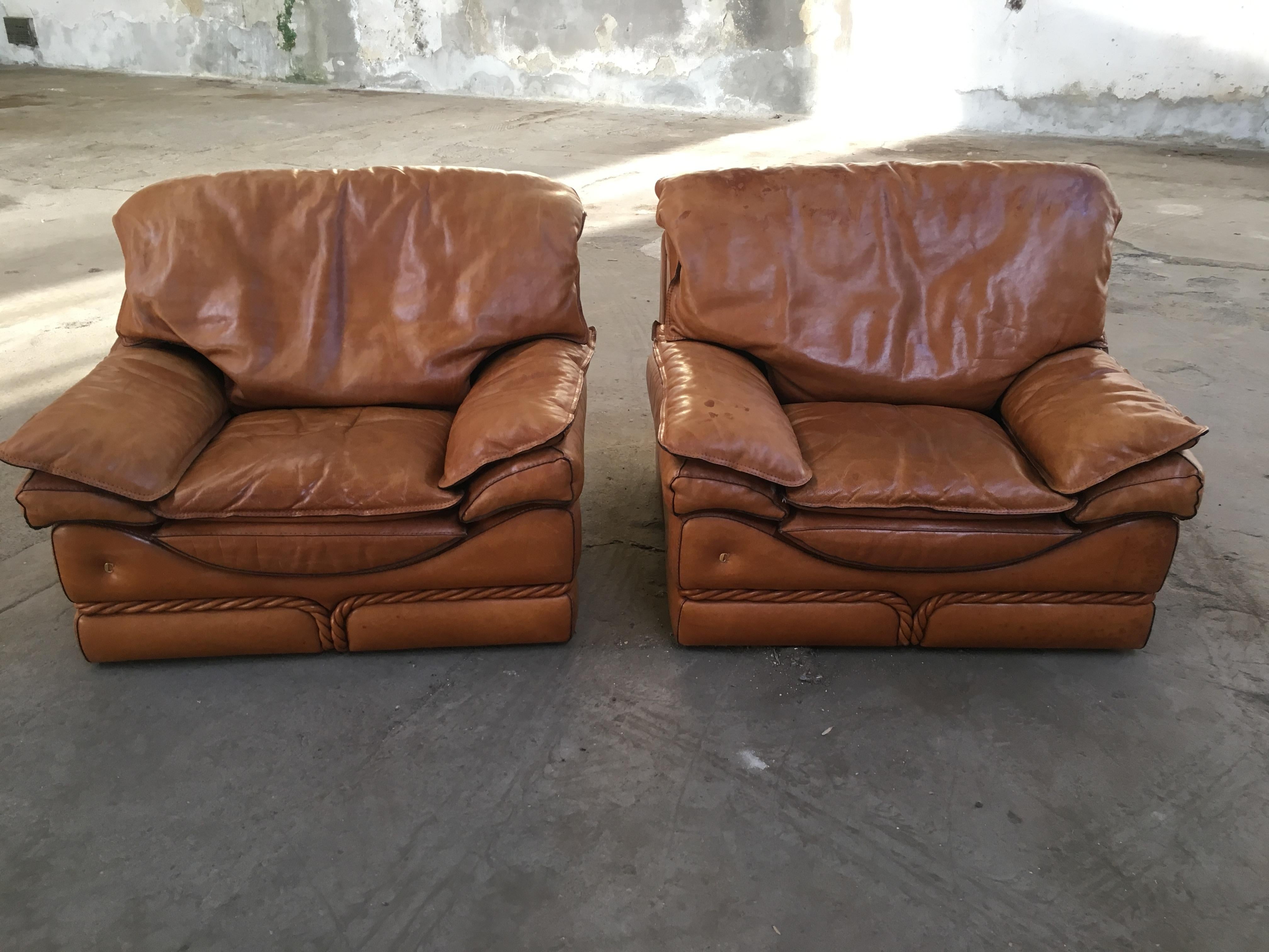 Paire de fauteuils en cuir naturel signés Mobilificio Colombo, datant de la fin des années 1970 
Les fauteuils sont ornés d'une superbe décoration en corde de cuir sur le devant, qui court tout autour de la structure, comme le montrent les