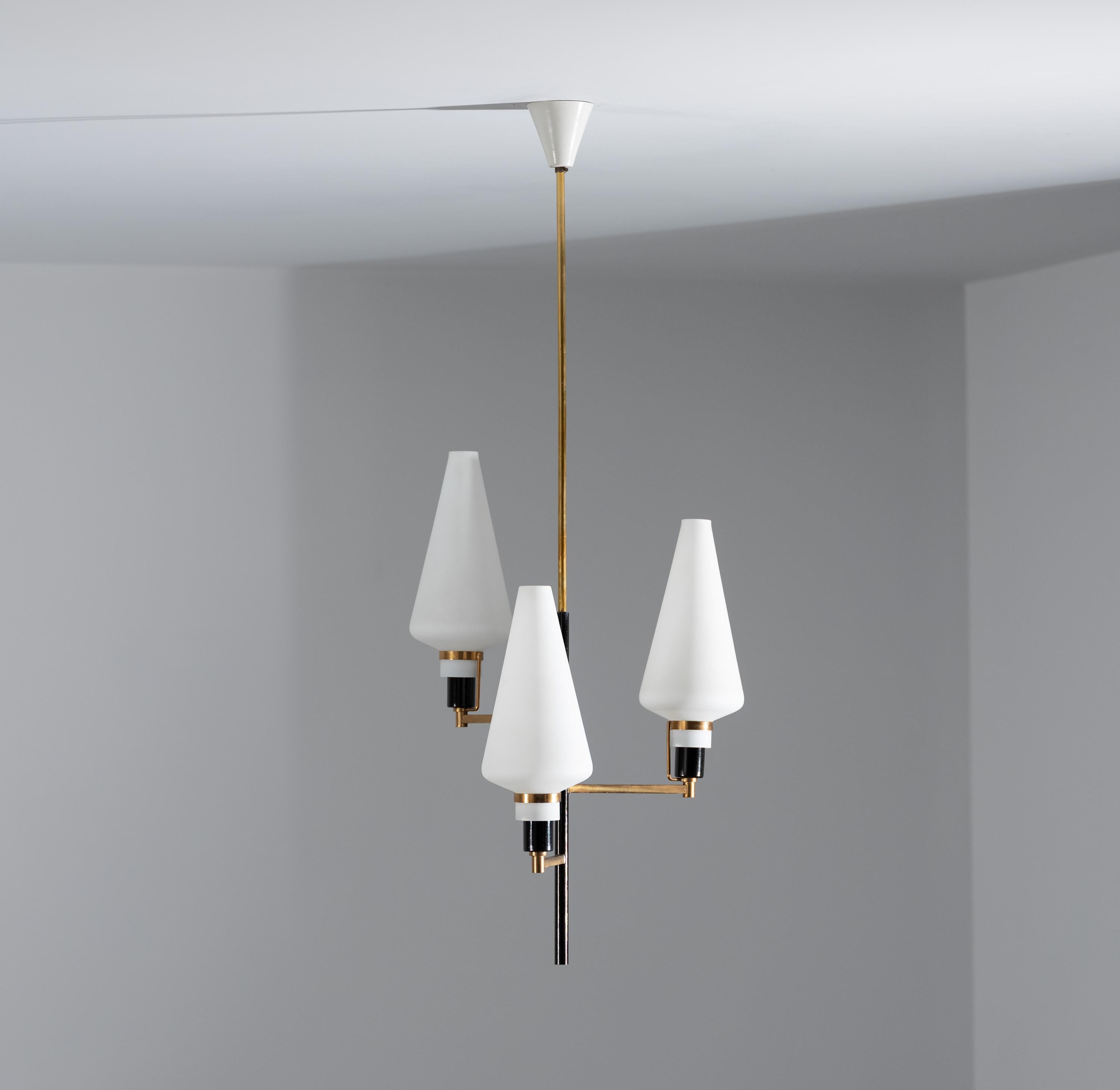 Presented here is a mid-century modern pendant chandelier, showcasing a blend of Italian design elements from the mid-20th century. The fixture features three upward-pointing conical diffusers made from opaline glass, which provide a soft