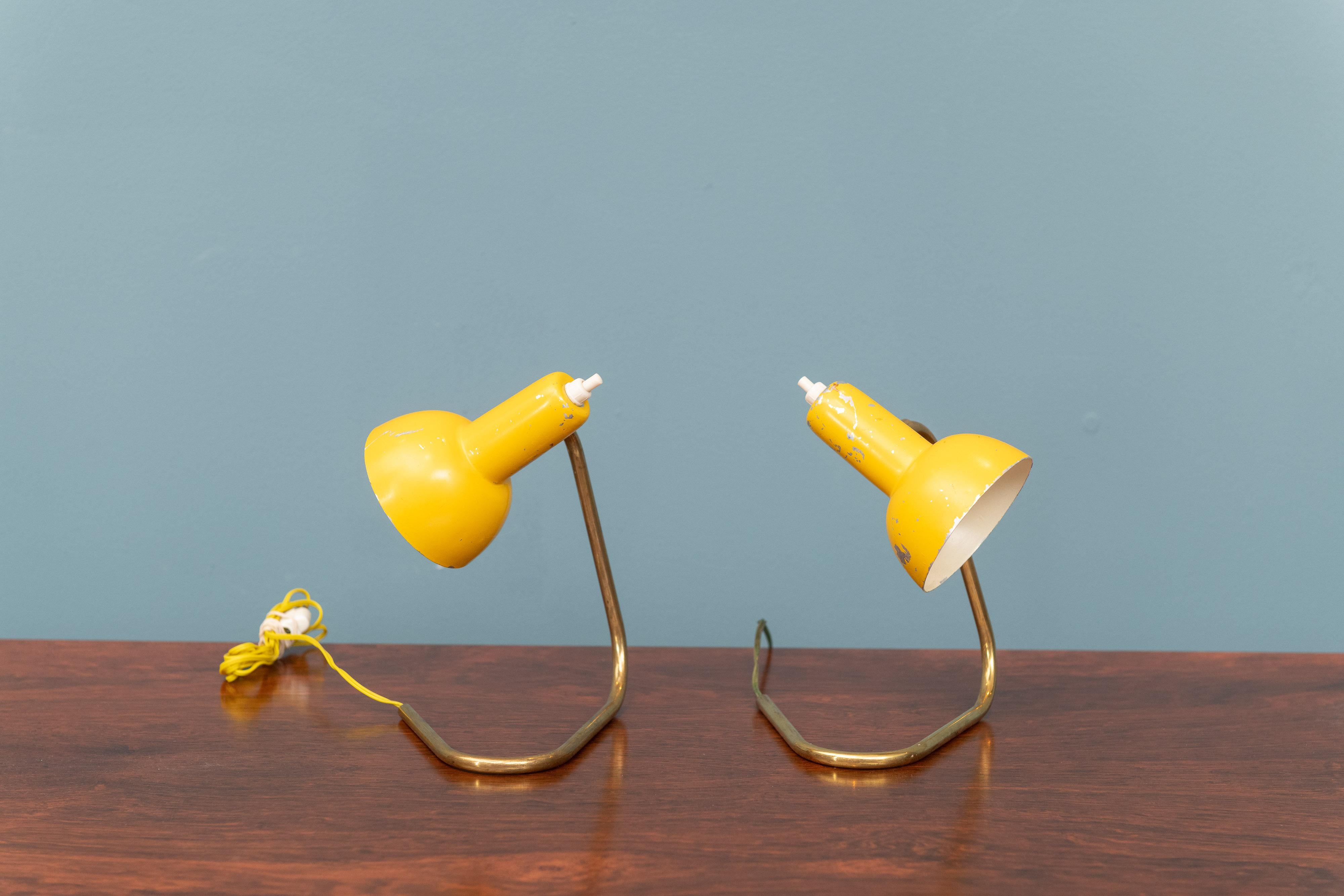 Mid-Century Modern Italian bedside or table lamps in yellow enamel with brass hairpin bases, perfect for smaller spaces. They will require new wiring for US standards.