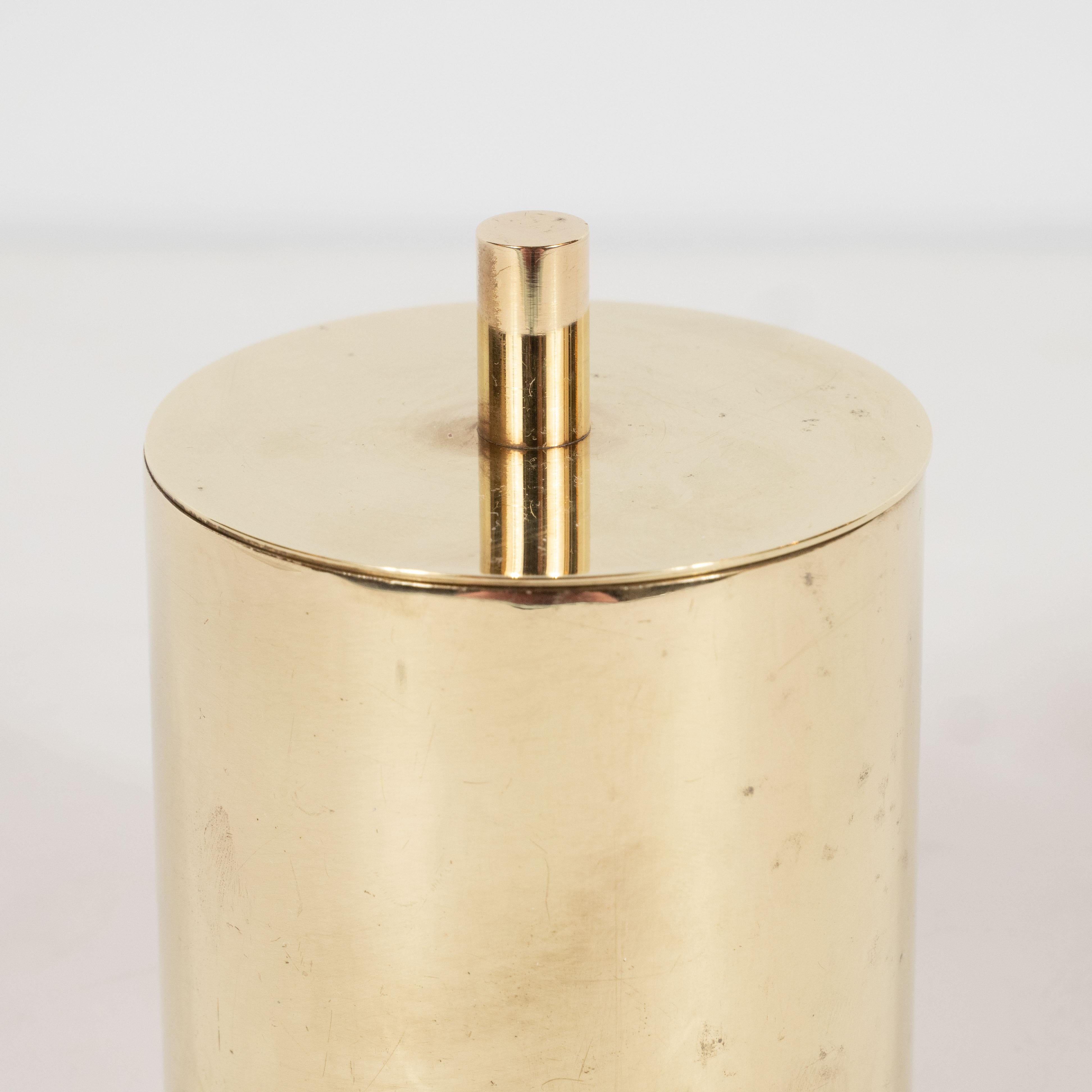 This refined Mid-Century Modern box was realized by the esteemed maker, Arredoluce, circa 1960. It features a cylindrical body with a circular top embellished with a finial that reiterates the form of the body in miniature. Replicating the form of