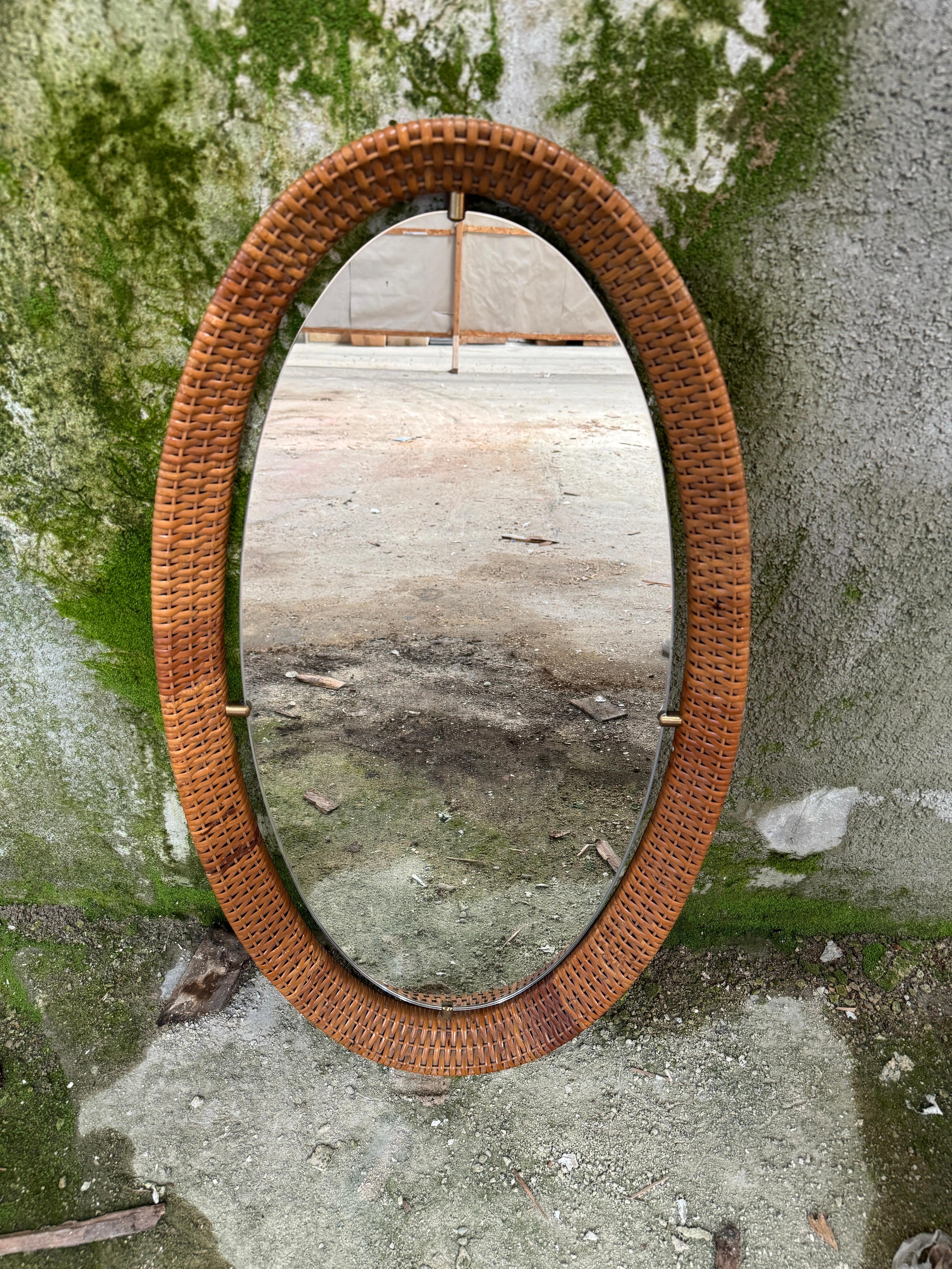 This stunning 1960s oval mirror is a perfect blend of natural elegance and vintage sophistication. Framed in beautifully woven rattan, it captures the essence of Mid-Century design with a warm, organic touch. The brass accents add a refined