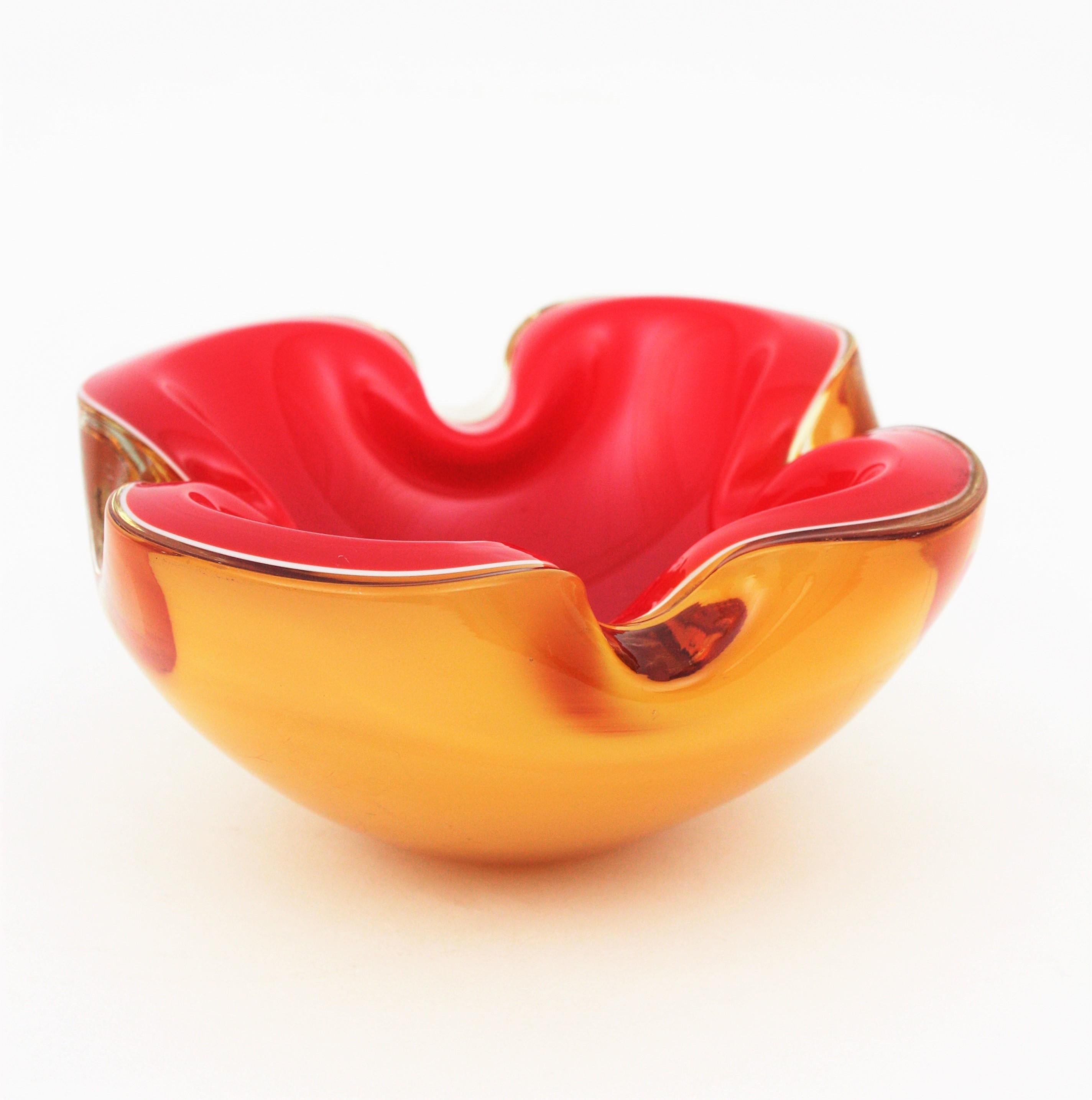 Amazing hand blown Murano glass bowl or ashtray in vibrant colors. Red glass and white glass cased into clear amber glass, highly decorative shapes and spectacular piece to combine with other Murano glass pieces or to use it alone. Use it as