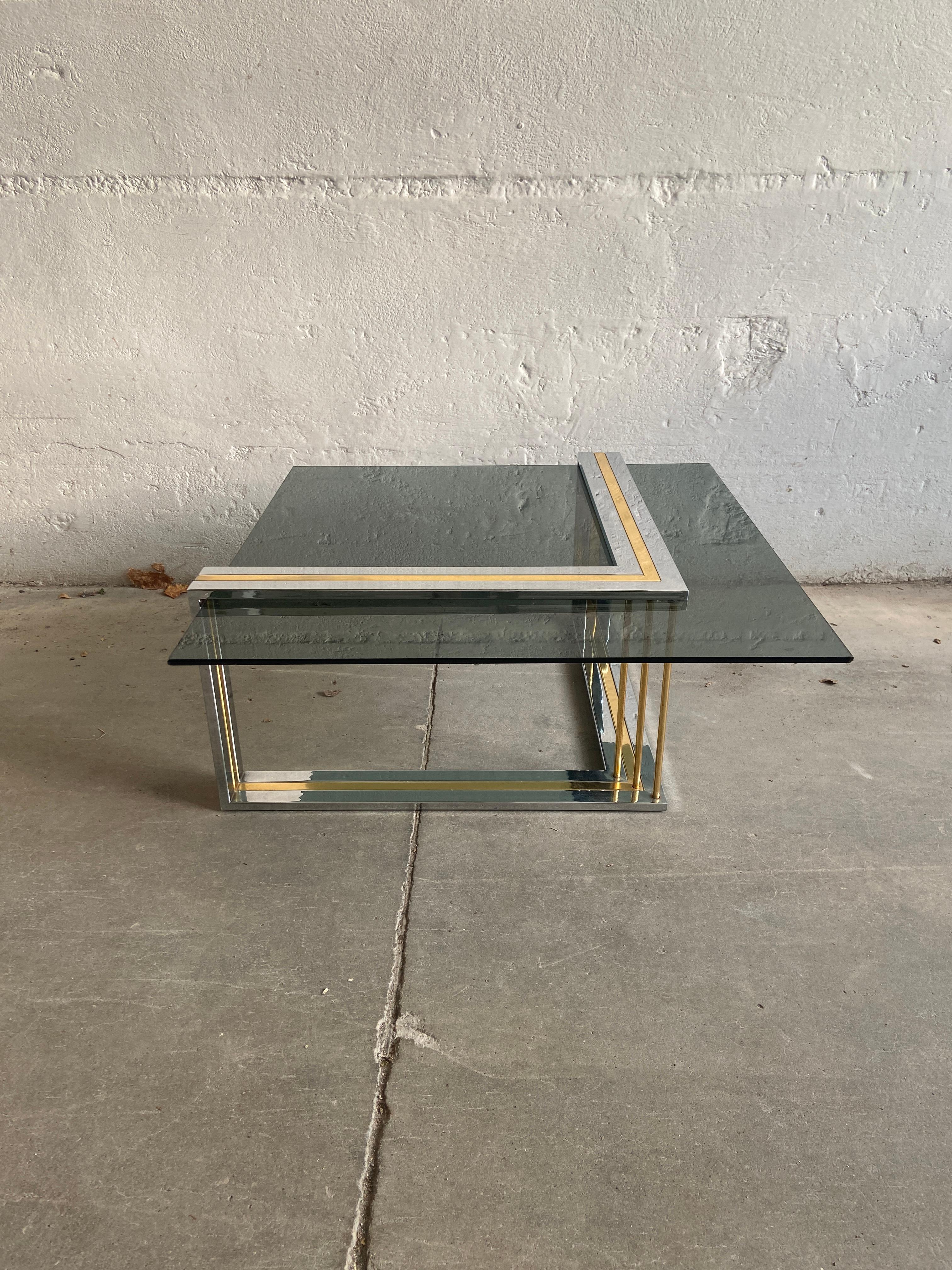 Mid-Century Modern Italian Romeo Rega coffee table with smoked glass top.
This stunning table has a particular and unusual asymmetric base.
The smoked glass top presents a pair of little chips in the corners but the table is in really good vintage