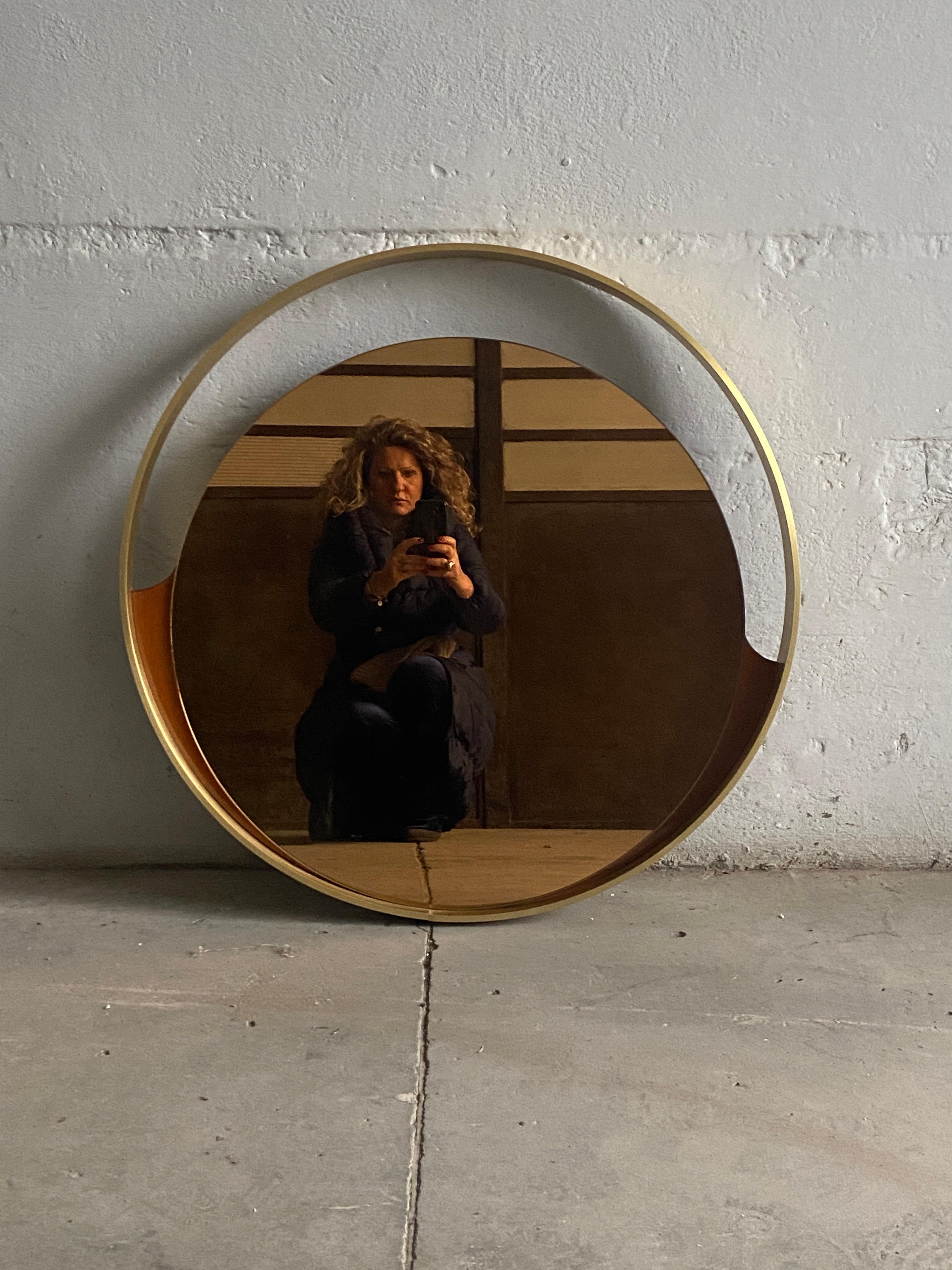 Mid-Century Modern Italian round gold colored mirror with gilt metal frame and wood details. 1970s.