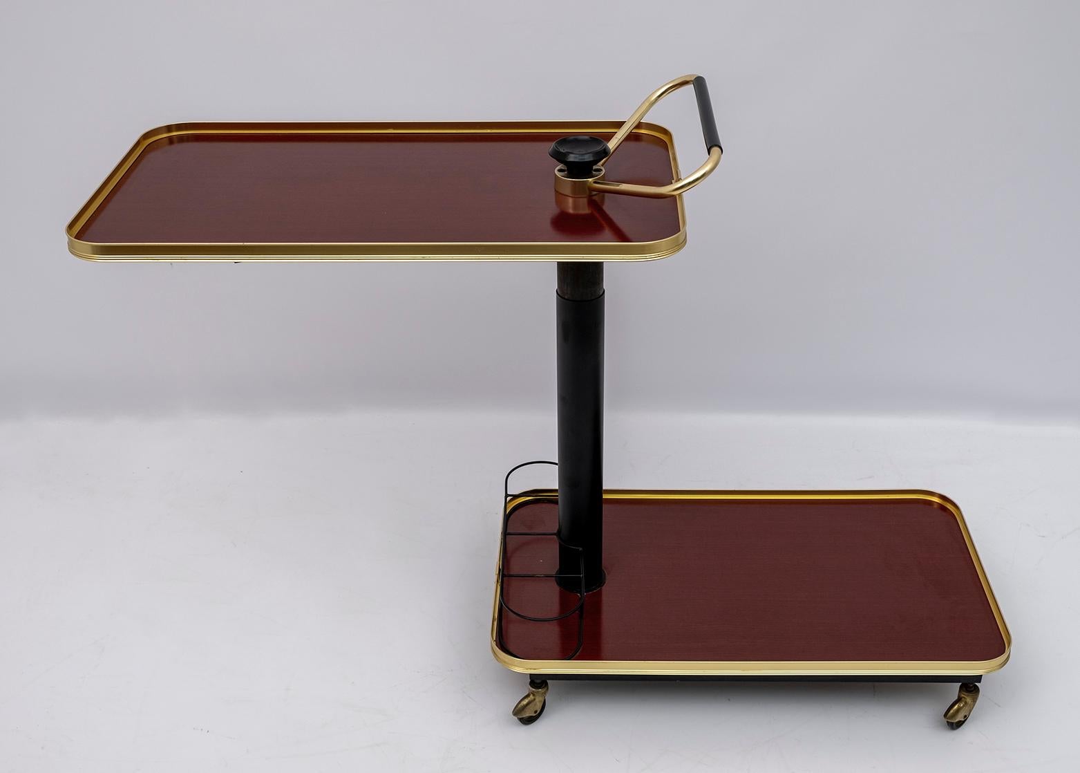 This formica and brass food trolley, was produced in Italy in the 70s, multifunctional, is adjustable in height and the upper surface, as shown in the photo, can rotate.