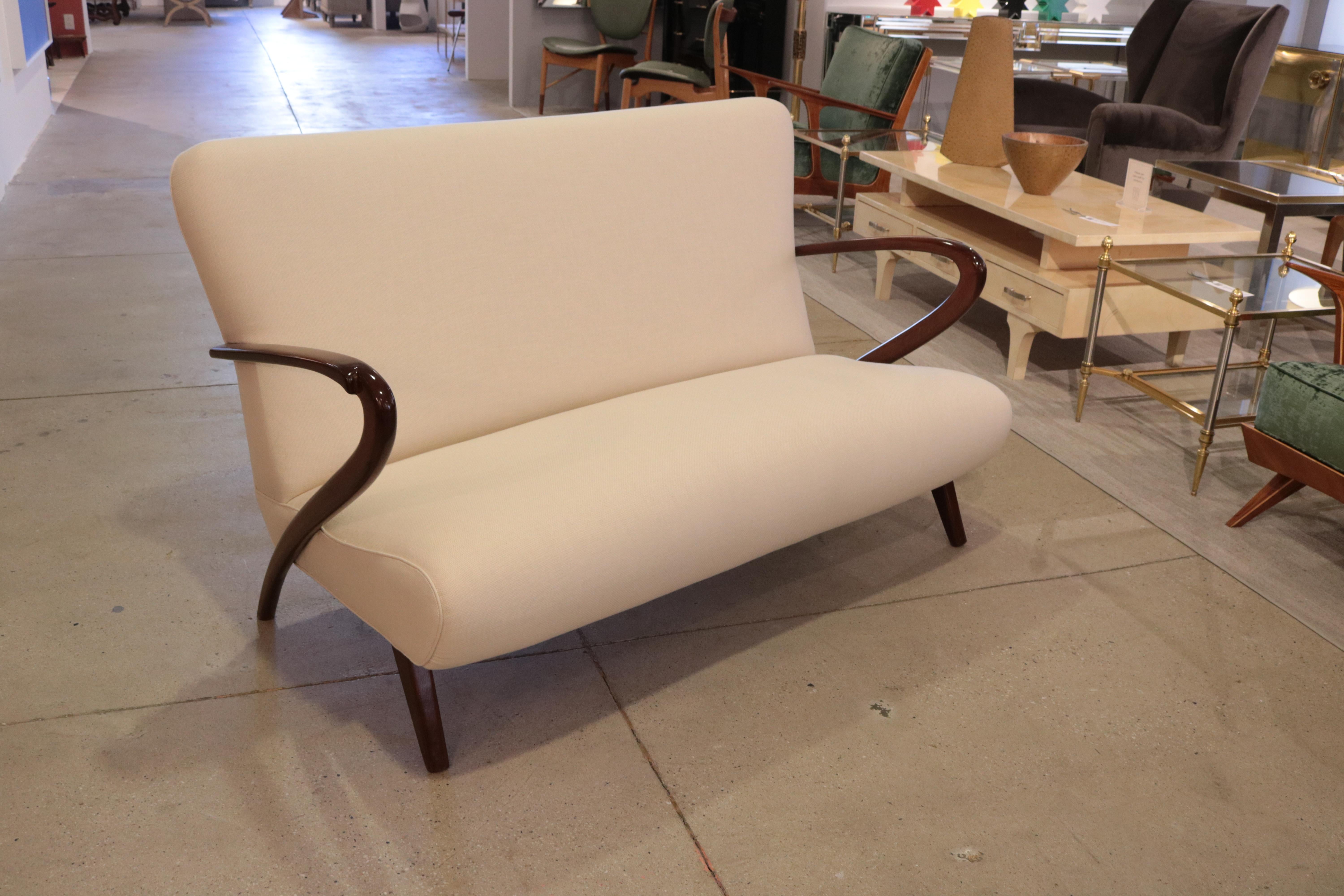 A Mid-Century Modern Italian setee. 
Mahogany arms and legs with new upholstery.