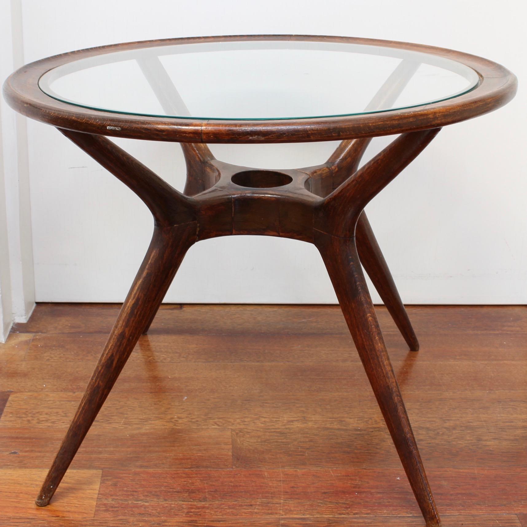 Mid-Century Modern Italian side table with glass top by Ico Parisi, (circa 1950s). In Parisi's iconic style with boomerang-shaped legs supporting a wooden frame and glass top (the original glass has been replaced with new glass). The wood has