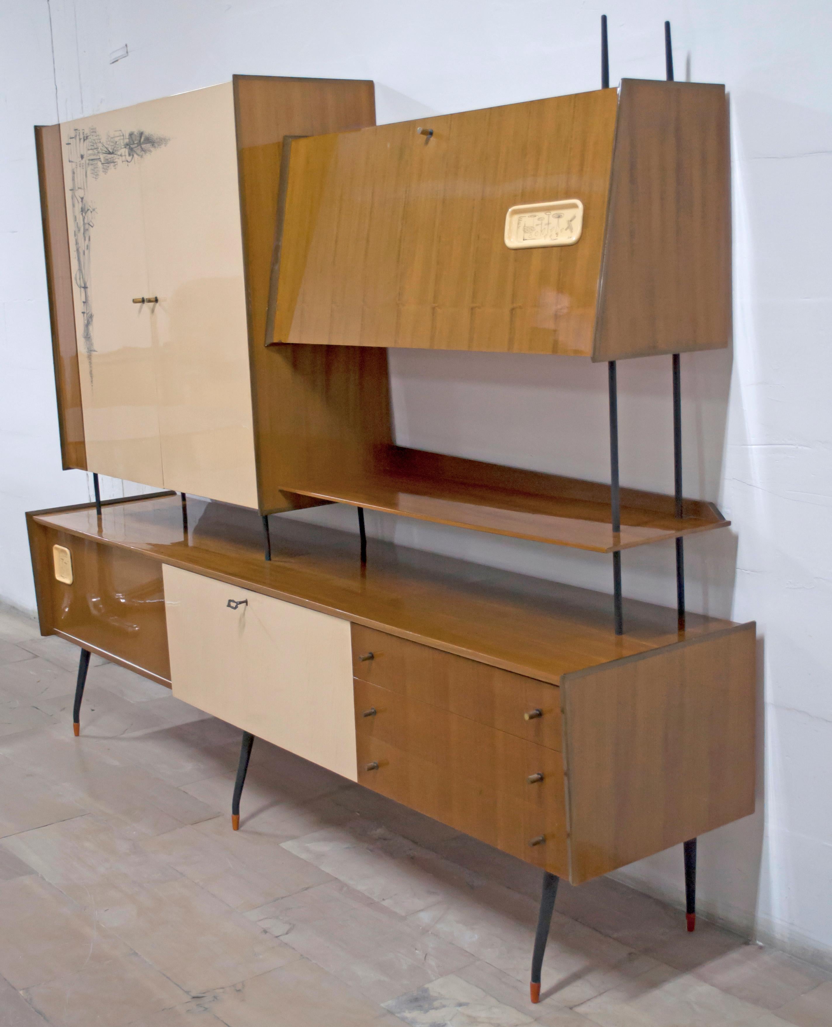 Sideboard, made of teak and birch. This piece of furniture has a sliding door, two flap doors, two side opening doors in birch wood, with decoration and three drawers. The legs are made of metal. This extravagant sideboard or bar cabinet is an