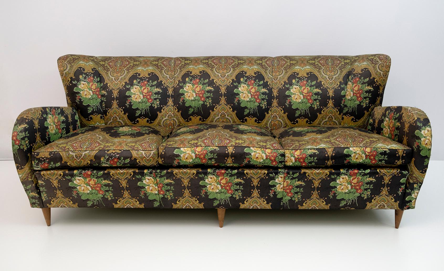 Italienisches dreisitziges Sofa aus den 1950er Jahren. Die Struktur und die Beine sind aus Buche und Tanne, die Kissen aus Gänsedaunen, das Sofa wurde in den 90er Jahren gepolstert, aber der Stoff ist verblasst und abgenutzt.
Condit wie auf den