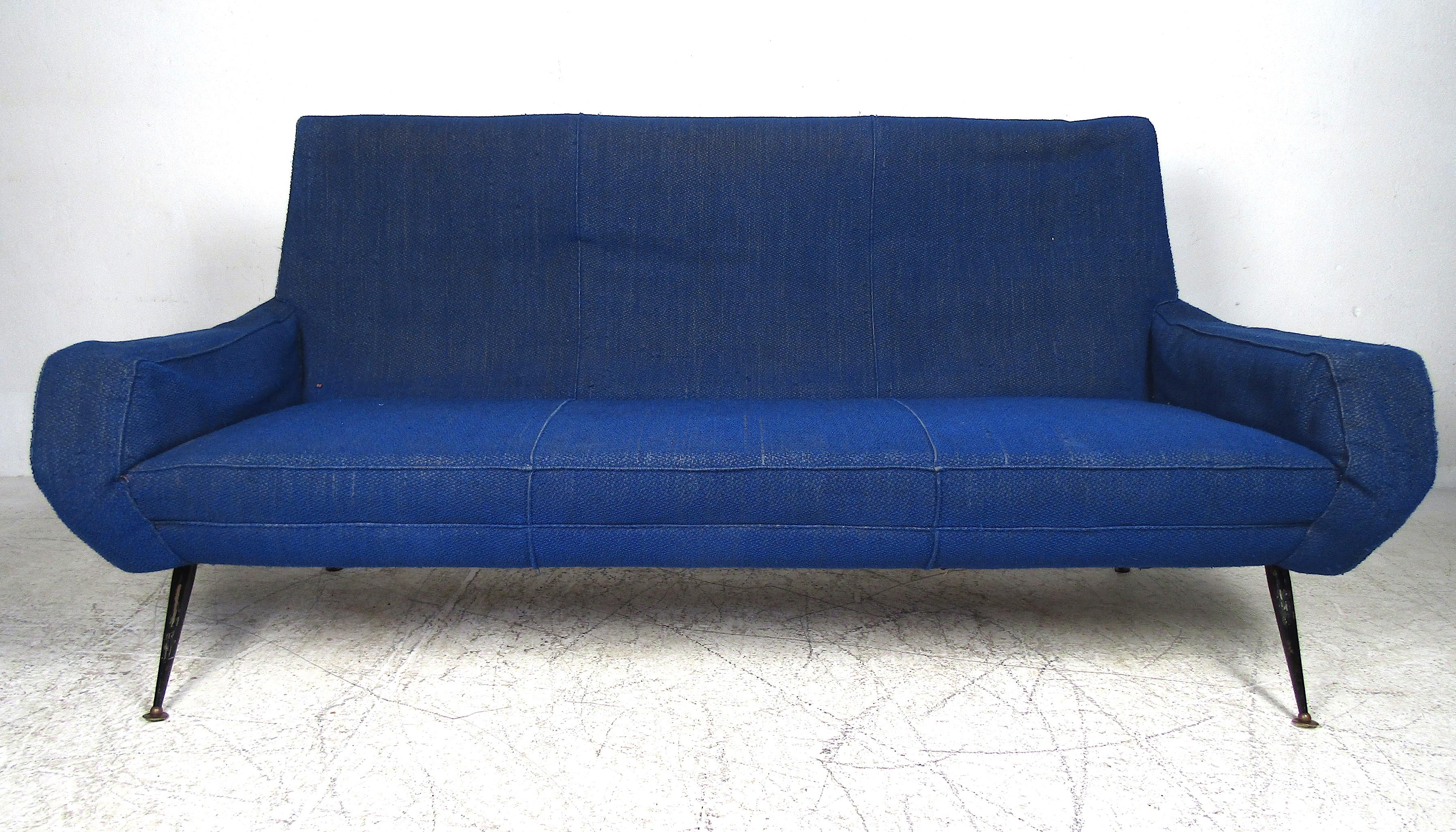 Ce magnifique canapé italien présente des accoudoirs sculptés ainsi que des pieds métalliques évasés. La sellerie bleu roi recouvre des sièges épais et rembourrés, garantissant un confort maximal. Cette pièce unique constitue un merveilleux