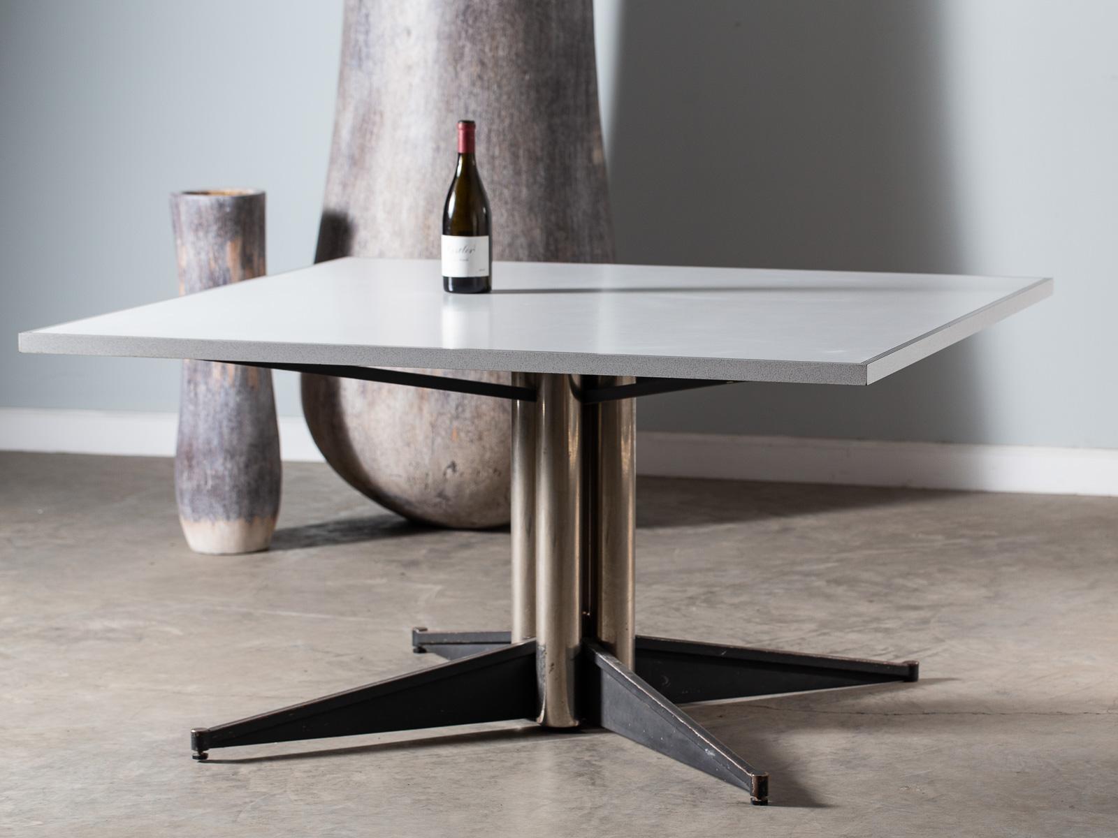 A vintage Italian Mid-Century Modern square steel base table, circa 1950. The cool Silhouette of the base on this table has four stainless steel cylinders surrounding the support shaft and stands on four modern horizontal legs. Seen from any