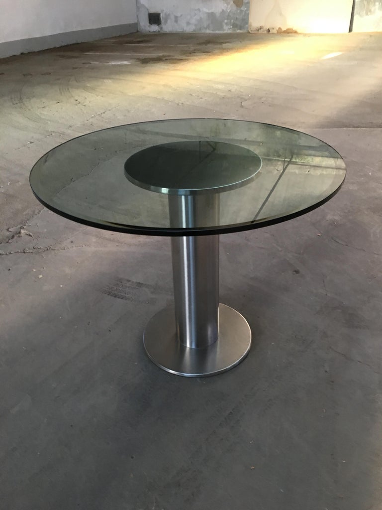 Mid-Century Modern Italian dining or center table with stainless steel chrome round basement and glass top. 1970s.
