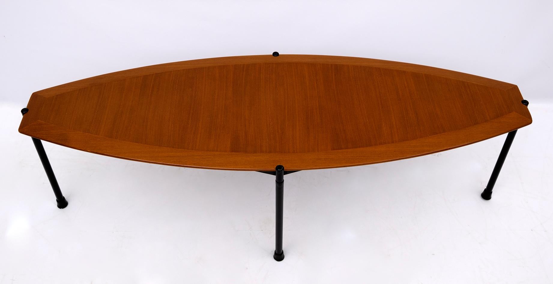 Table basse particulière des années 70, plateau en placage d'acajou et base en métal, la forme rappelle celle d'une planche de surf.
