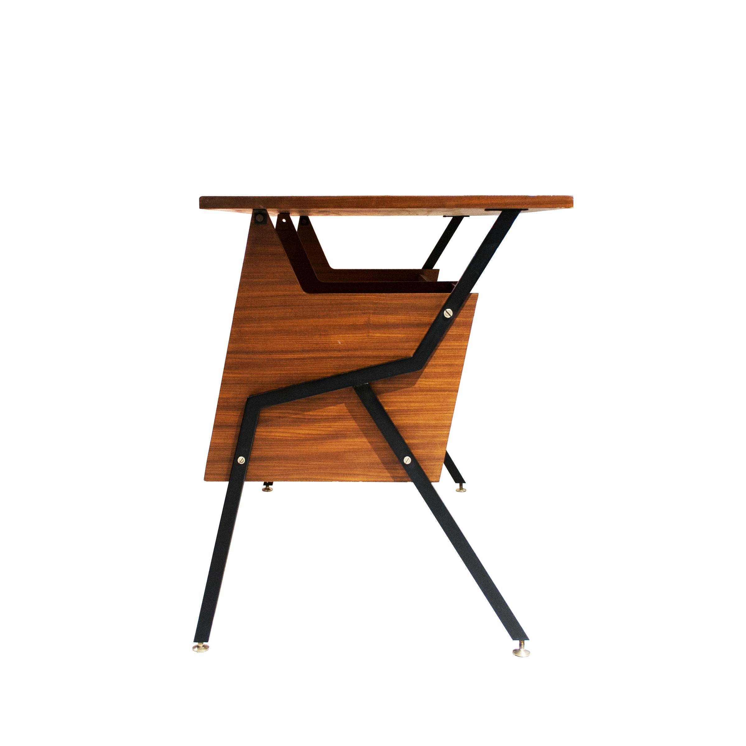 Mid-Century Modern Italian desk made of teak wood supported by a geometrical angled structure of black lacquered iron with brass details. The desk is compossed of front and lateral wood panels with a drawer module on the right side and a table top.