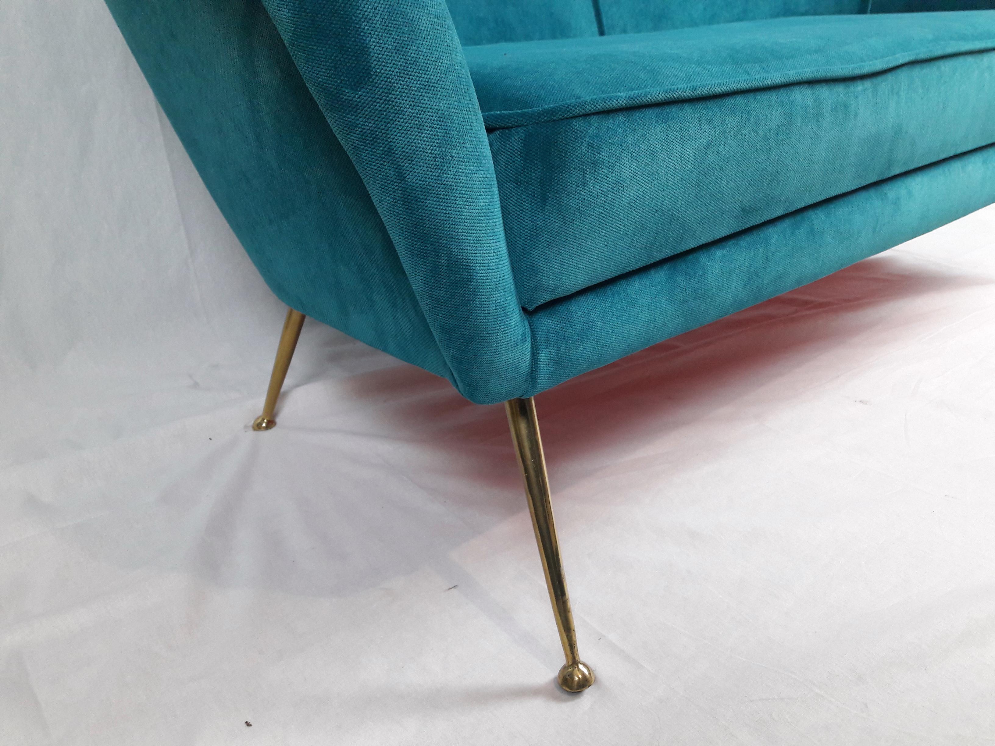 Enchanting two-seat Italian 1950s sofa characterized by typical brass 'stiletto' legs, curved line back and armrests. Reupholstered in new turquoise velvet fabric.