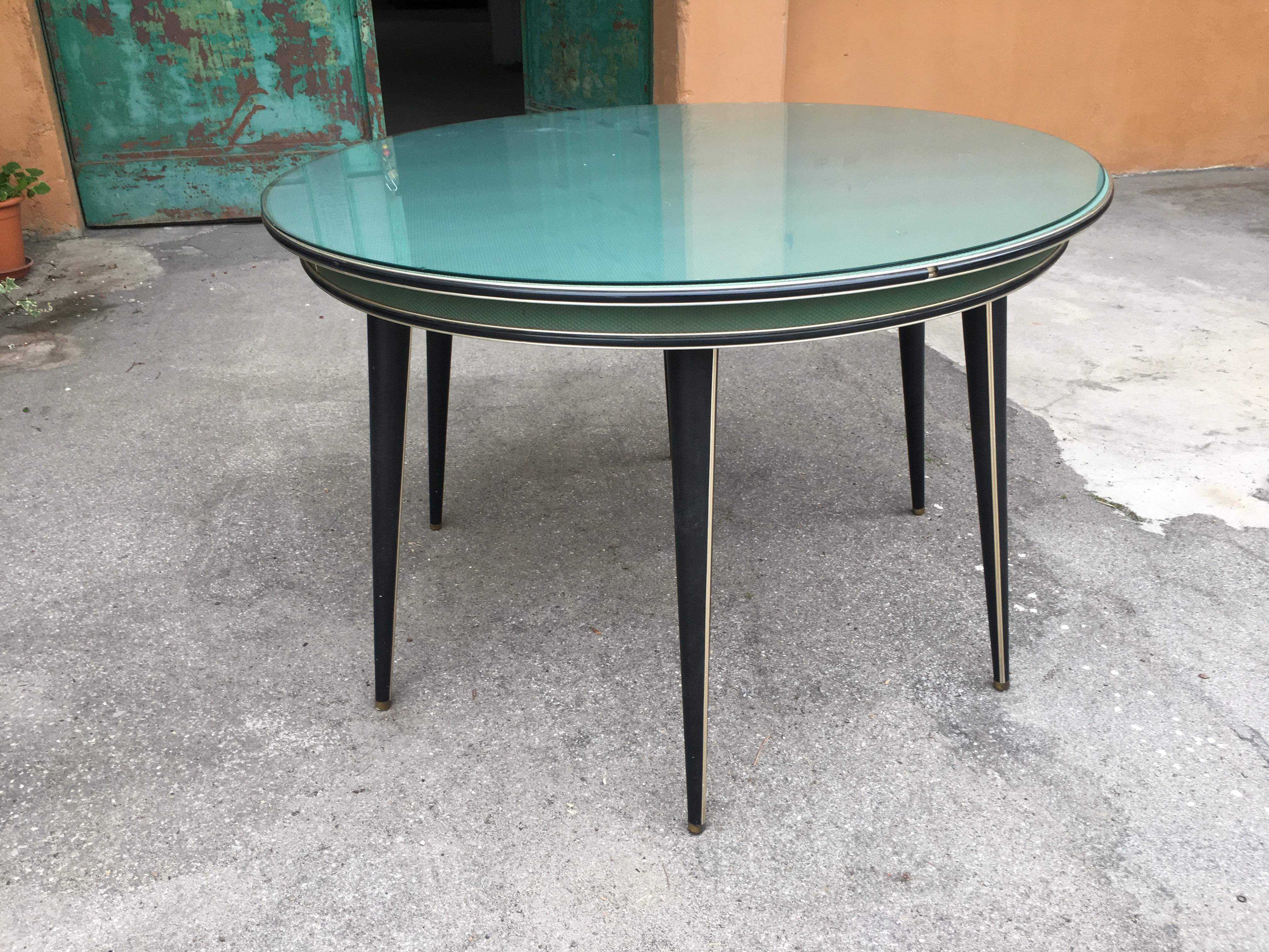 Moderner italienischer runder Tisch mit sechs Beinen in Grün und Schwarz von Umberto Mascagni aus der Jahrhundertmitte.
Die Tischplatte ist aus Kunstleder und mit Glas überzogen und wird mit einer grünen Stoffhülle geliefert, wie auf den Fotos zu