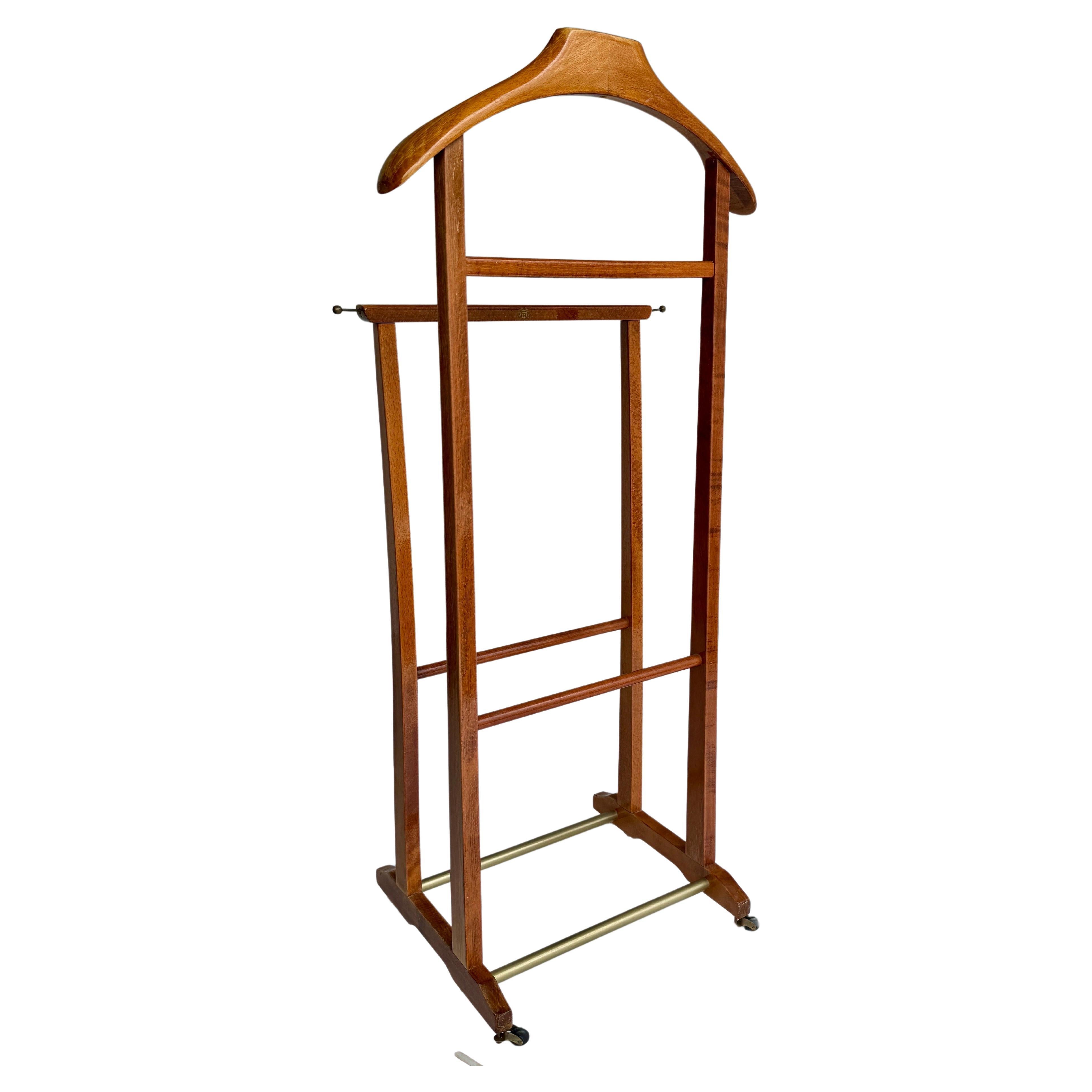 Mid-Century Modern valet stand dressboy, in the manner of Ico and Luisa Parisi. This valet is made by Fratelli Reguitti in the 1960's Italy. 
This vintage beechwood men's valet is elegant and timeless with brass hardware and caster wheels for simple