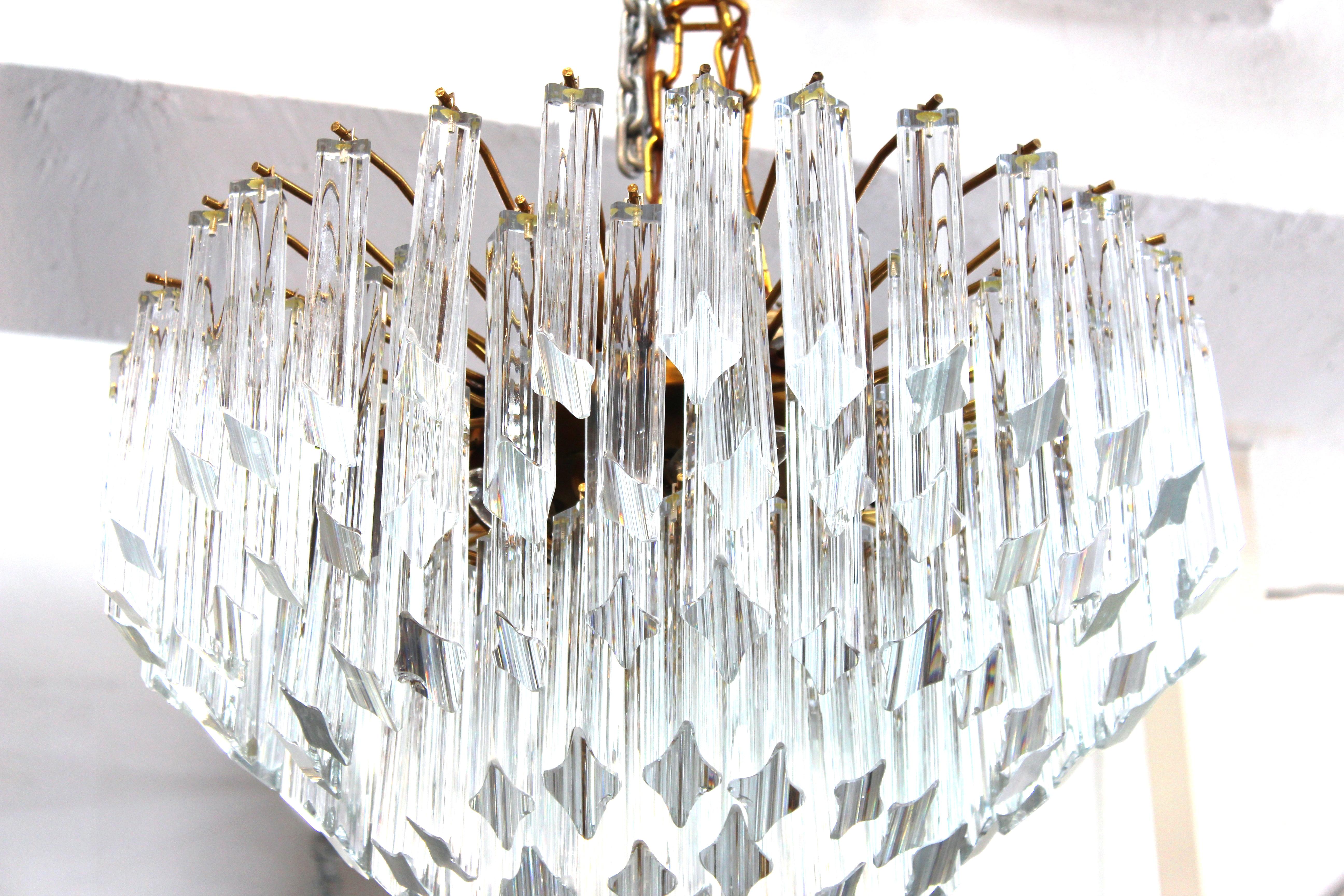 Mid-Century Modern Italian Venini 'cake' chandelier made of descending stacked layers of quadriedri prisms. The piece was made in Italy during the 1960s-1970s and is in great vintage condition. Slight clam-shell chips to the lower parts of some
