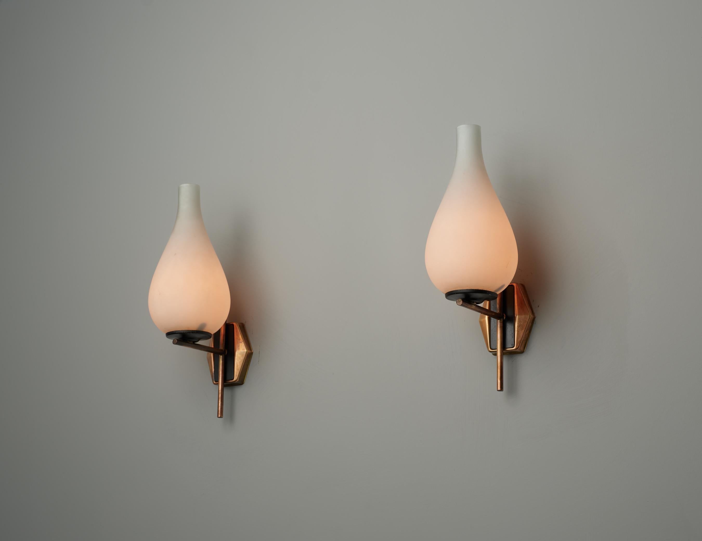 Ein Paar elegante Wandleuchten aus der Mitte des Jahrhunderts, die in den 1960er Jahren in Italien entstanden sind. Jede Leuchte verfügt über eine schlichte, minimalistische Messinghalterung, die einen Opalglasschirm mit einer glatten,