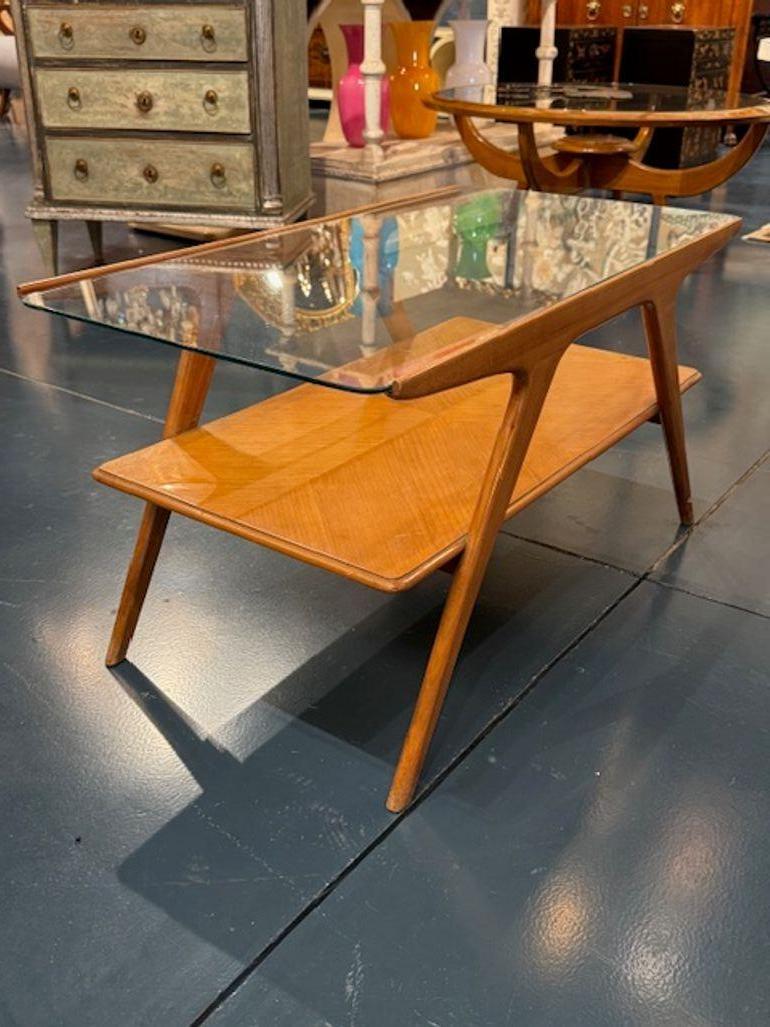La table basse en noyer et verre de style italien moderne du milieu du siècle est une élégante table basse de style italien du milieu du siècle.  meuble. Cette table basse intéressante dégage un charme sophistiqué qui convient parfaitement à tout