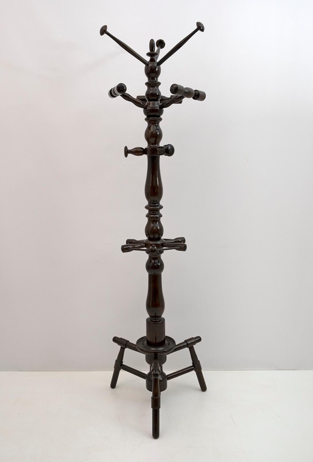Particular and impressive coat stand with umbrella stand in turned walnut, produced in Italy in the 1950s. It has been restored and polished with shellac.
The coat hanger is made up of various hangers, the central part is designed to hang