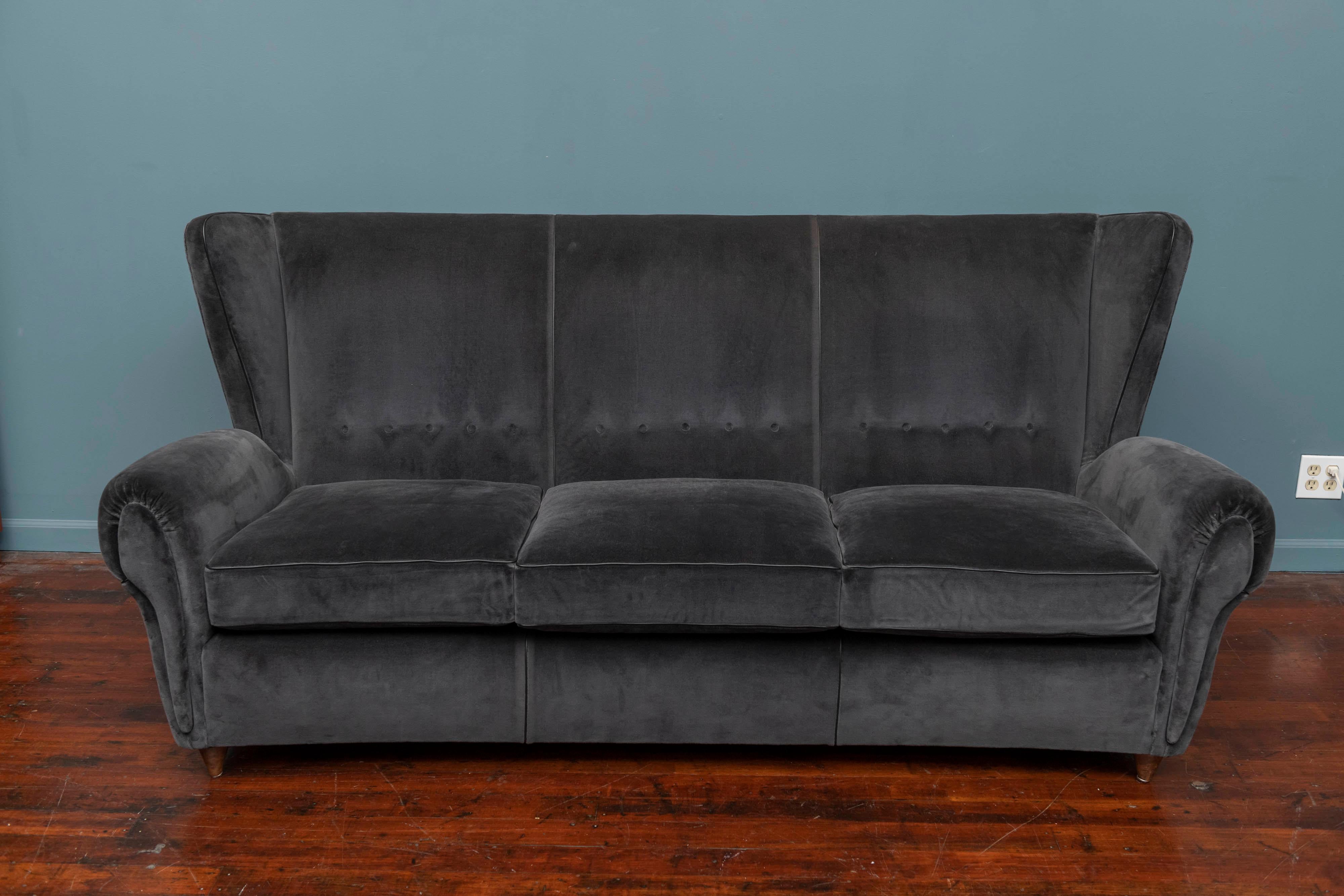 Mid-Century Modern Italian wingback sofa, upholstered in charcoal mohair with black leather piping. Completely restored and ready to install, very comfortable.
