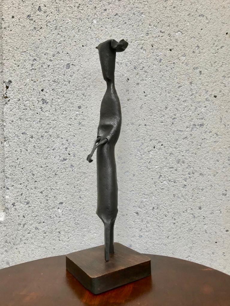 A signed Italian abstract sculpture of a nun walking with hands held in prayer. The nun shown wearing a 'cornette' wimple headdress, like that of the flying nun. Signature etched into base.