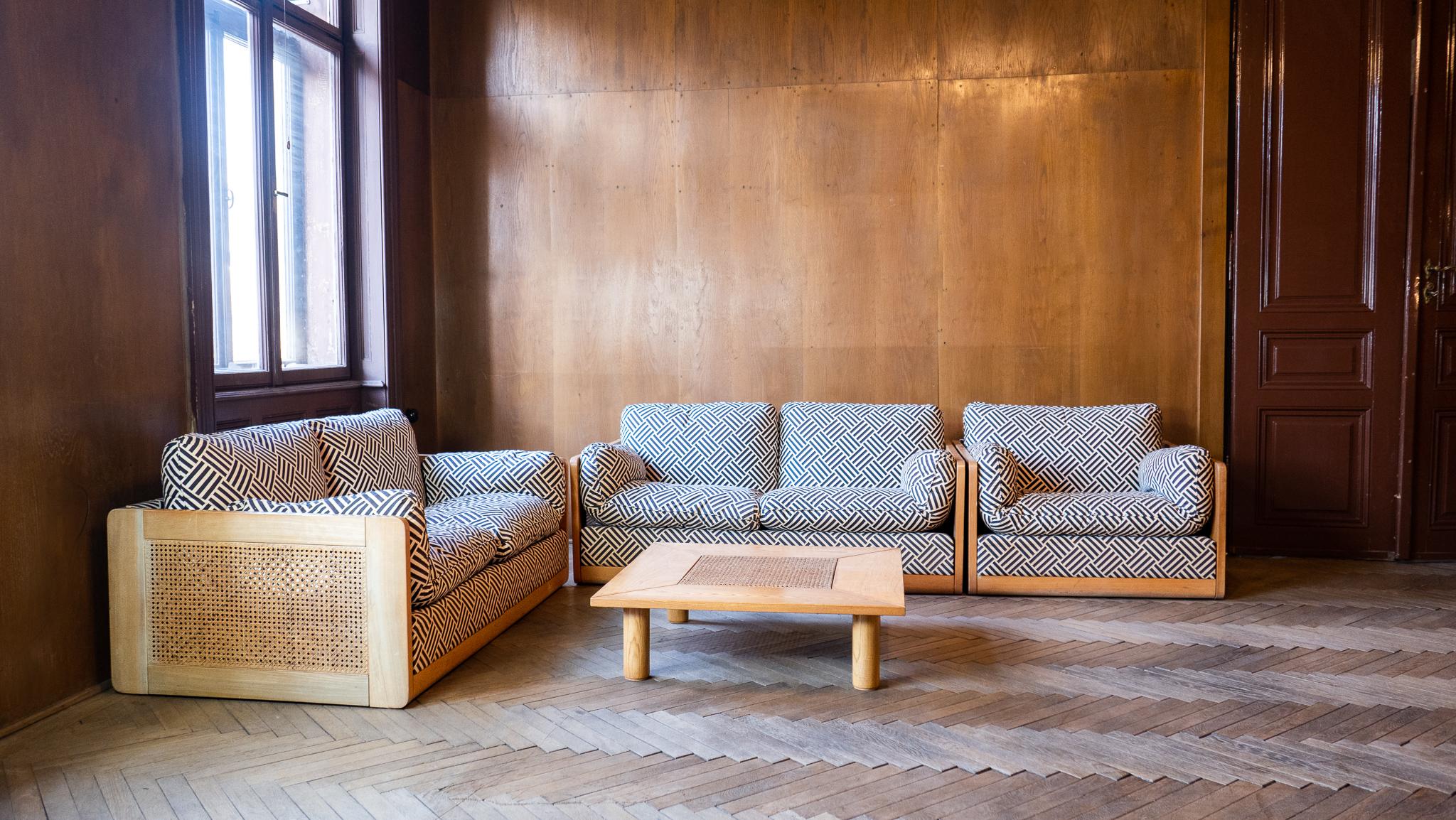 Mid-Century Modern Italien Holz Rattan Set von 2 Sofas und Stuhl, Italien 1970er.

Diese schöne italienische Garnitur aus 2 Zweisitzer-Sofas, 1 Sessel und 1 Couchtisch aus Birke und Rattan - auch Wiener Stroh genannt - mit dicker Polsterung lädt den