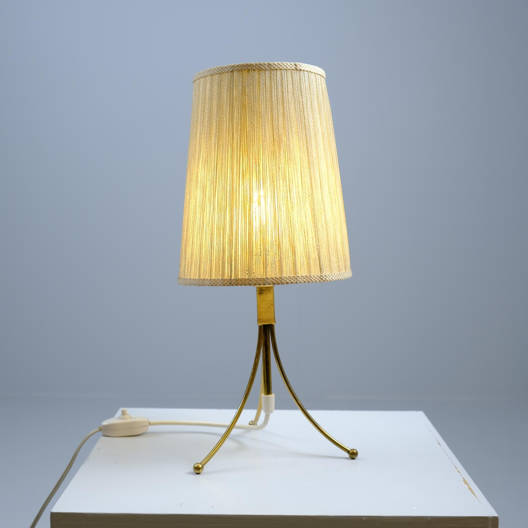 Lampe de table minimaliste du milieu du siècle dernier, modèle EV 67, fabriquée par Itsu en Finlande dans les années 1950. Design/One élégant et épuré, composé de trois pieds courbés en laiton massif, reliés par une coupelle centrale en laiton
