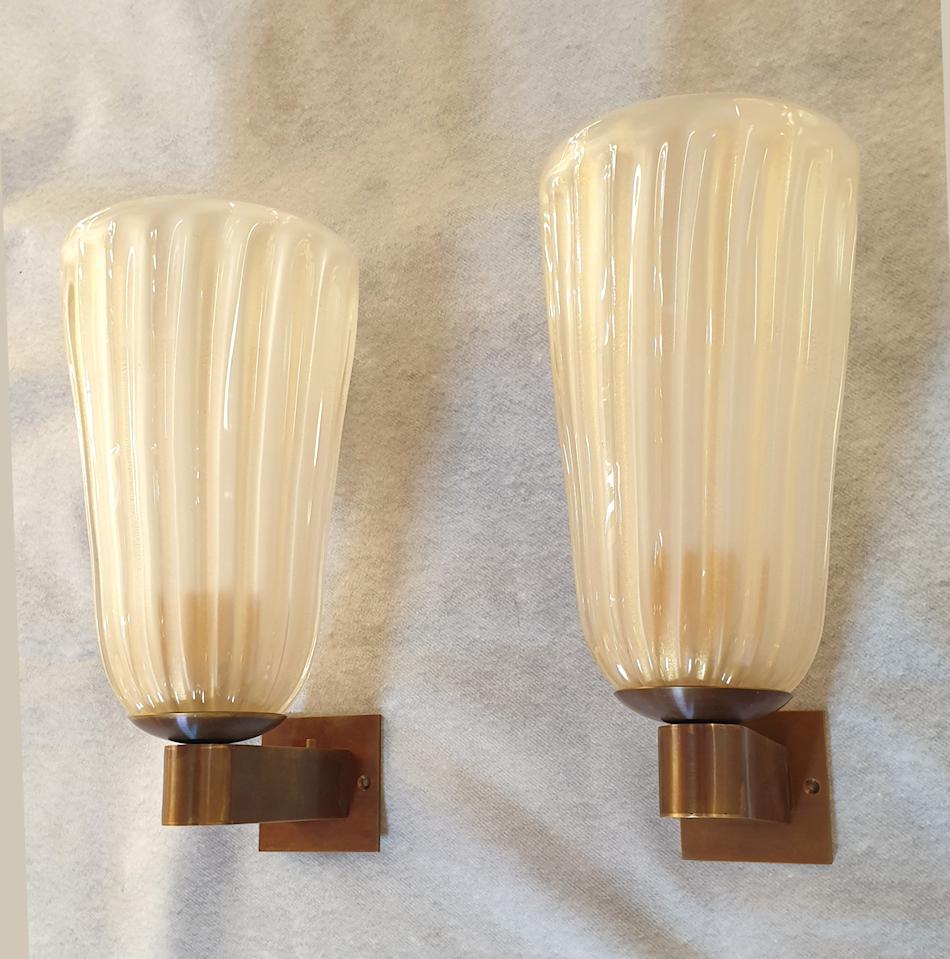 Pair of Mid-Century Modern ivory Murano glass sconces, 
The vintage sconces are made of handmade Murano glasses by Barovier & Toso, Italy, 1970s.
The Murano glasses are translucent and create a warm light.
The mounts are new: with an old brass