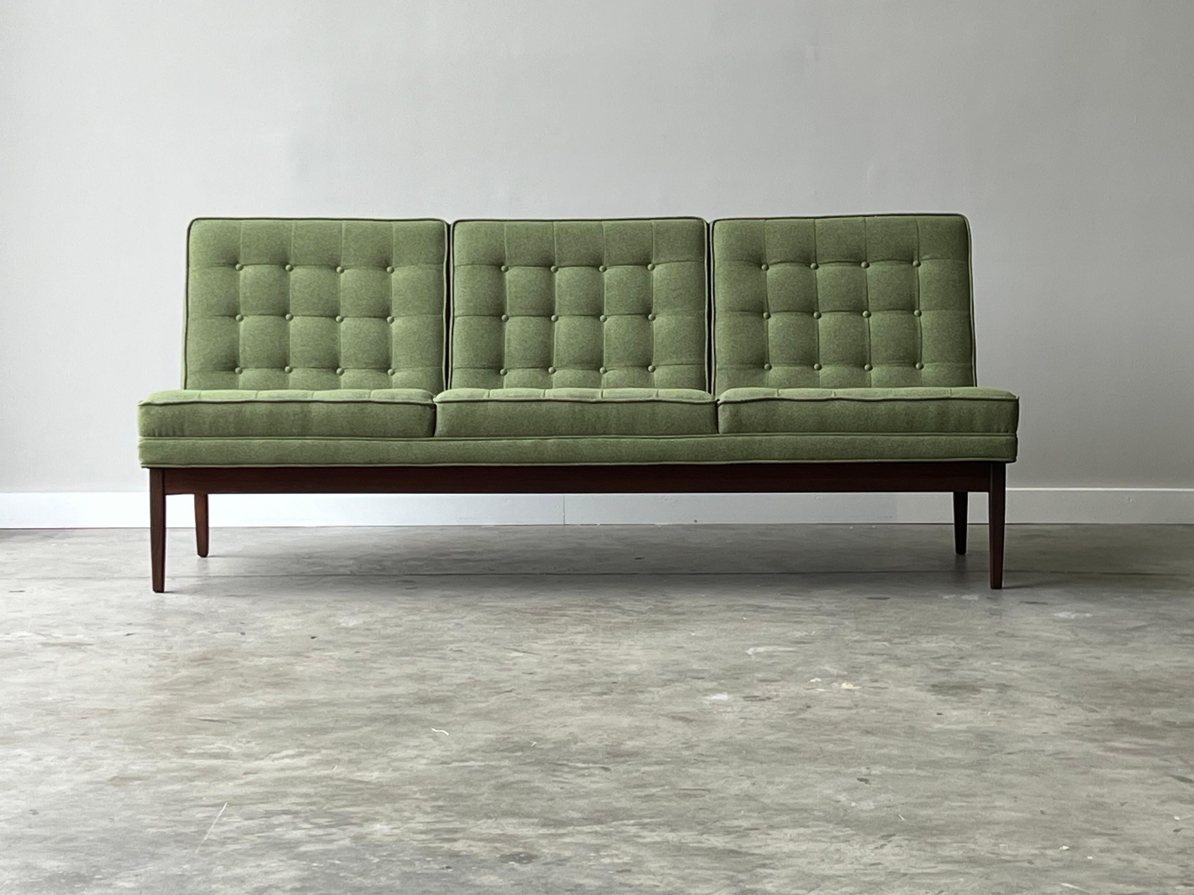 Mid-century three seater sofa designed by Jack Cartwright for Founders, circa 1960s. Cushions have been newly reupholstered and tufted in a vibrant green knit fabric. Pleasing to the eye and soft to the touch. Cushions sit on a walnut frame with