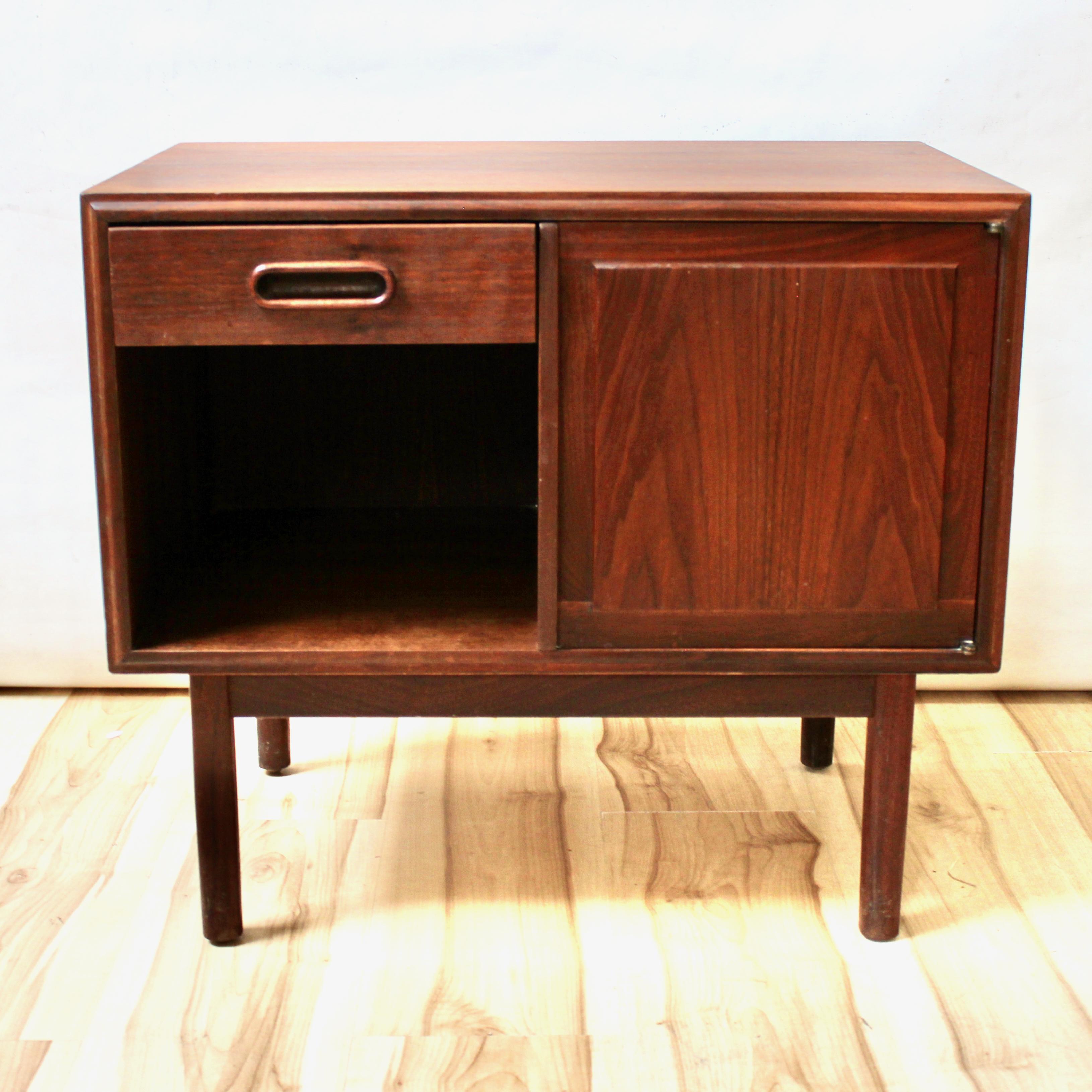 Mid-century modern walnut nightstand or small cabinet by Jack Cartwright for Founders Furniture. The nightstand has one drawer, and a cabinet section with a magnet closure. In excellent condition.

Width: 26 in / Depth: 16 in / Height: 23 in.