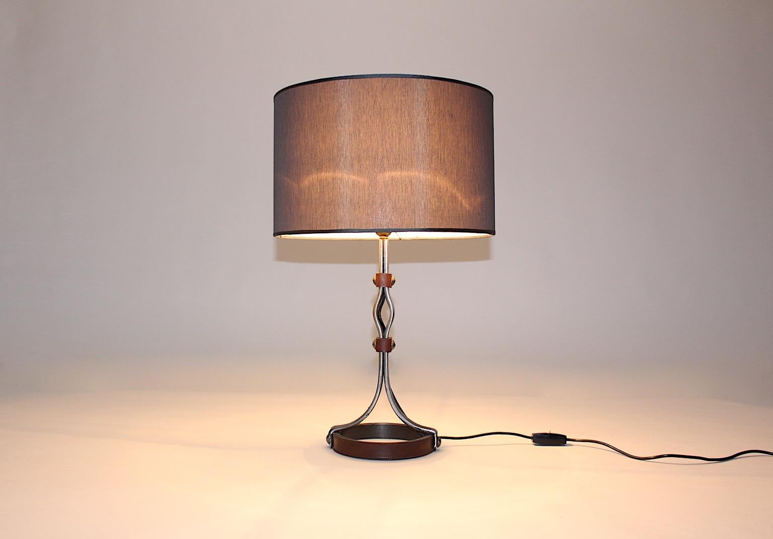 Mid-Century Modern vintage table lamp from iron and stitched leather attributed to Jacques Adnet 1950s France.
The beautiful table lamp from iron construction partly wrapped with stitched leather shows design which is attributed to Jacques Adnet