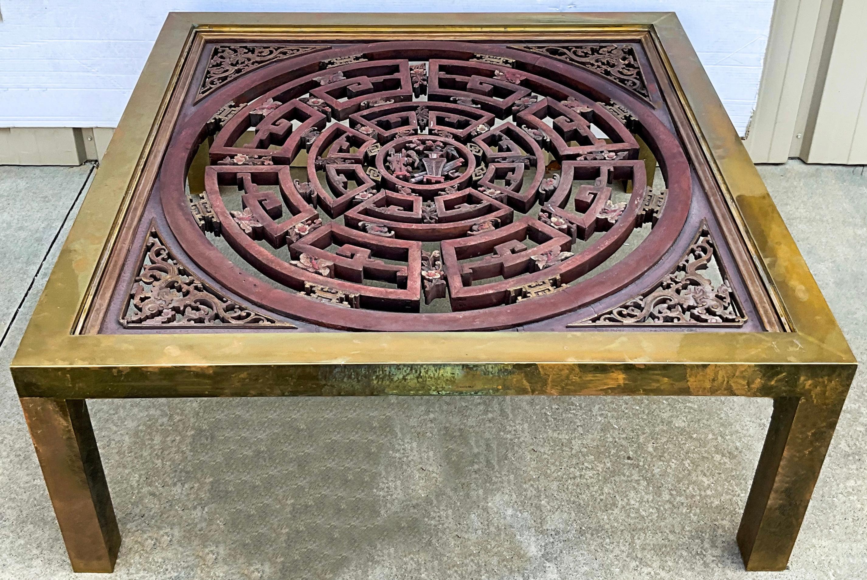 This is mid-century modern James Mont style brass and carved wood coffee table with Asian influences. The juxtaposition of the brass frame with the large scale carved medallion give it strong decorative appeal! The brass is notably tarnished but in