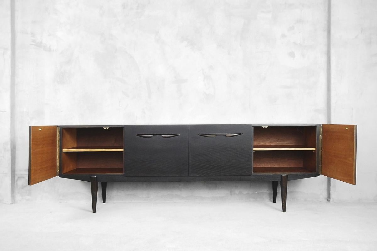 This Minimalist sideboard was manufactured in Japan during the 1960s. It was made from two kinds of wood - ash and oak. The wood has been burned and finished in deeply brown tone but not black. The final wood layer has a regular and strong grain.