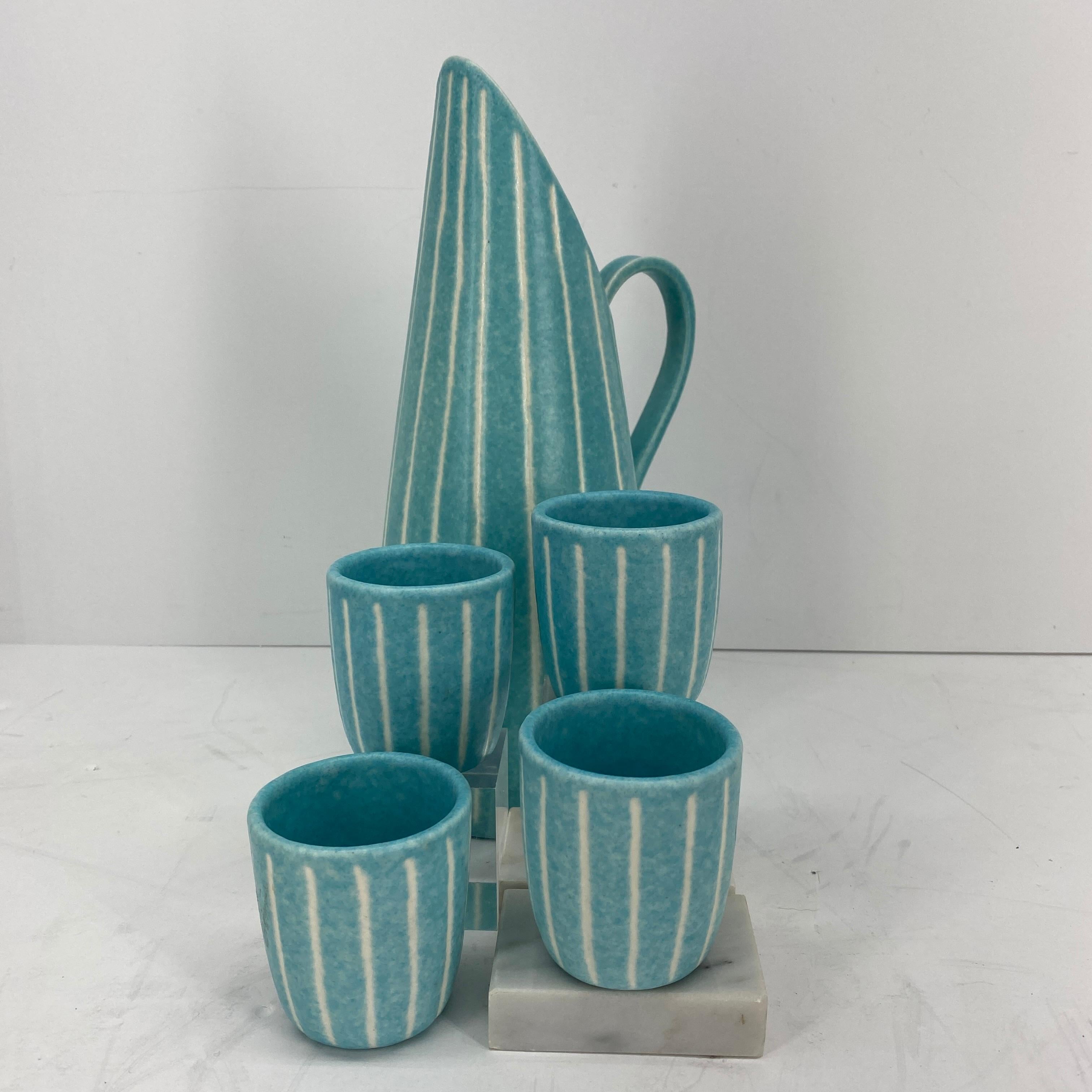 Iconic Mid-Century Modern from Southern California design. Rare and in very good condition, with its bright turquoise and creamy stripes, this beverage set, pitcher and 4 cups/beakers by Jaru of California, will make every cocktail hour even
