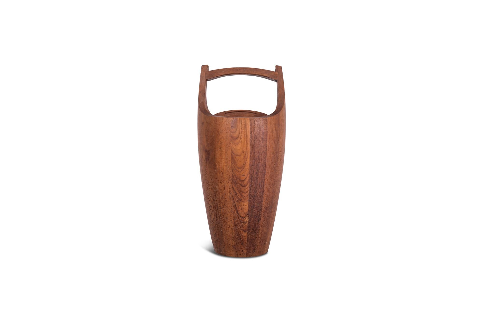 Danish ice bucket in solid teak. The wood shows a beautiful grain and provides this object with a nice, elegant and warm appearance. The red / bright orange acrylic liner contrasts nicely, the bucket comes in very useful to cool your favourite