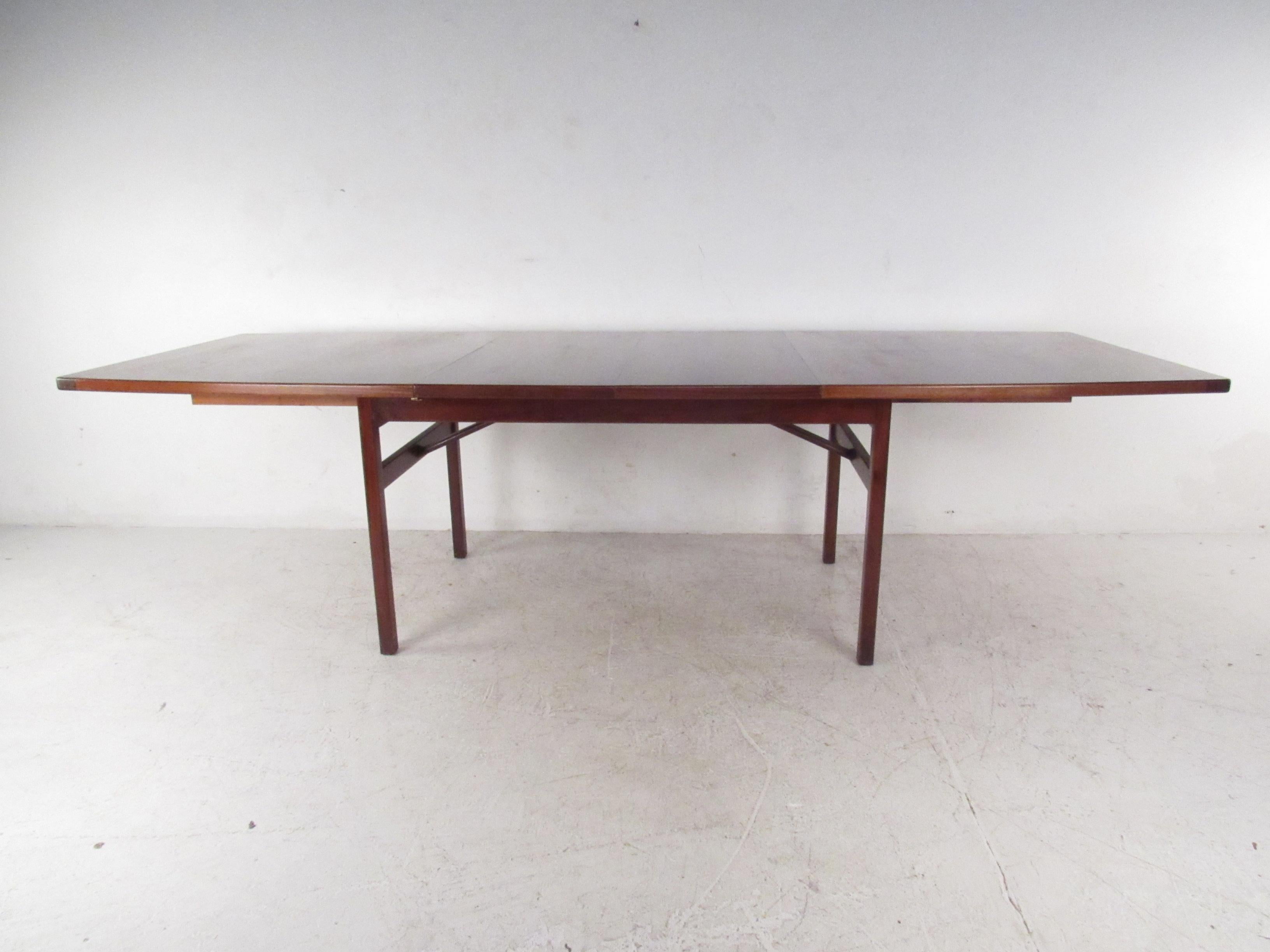 This wonderful vintage modern dining table by Jens Risom Design features a uniquely top that comes with two additional leaves. A well made piece in walnut that easily caters to many guests without sacrificing style. Please confirm item location (NY
