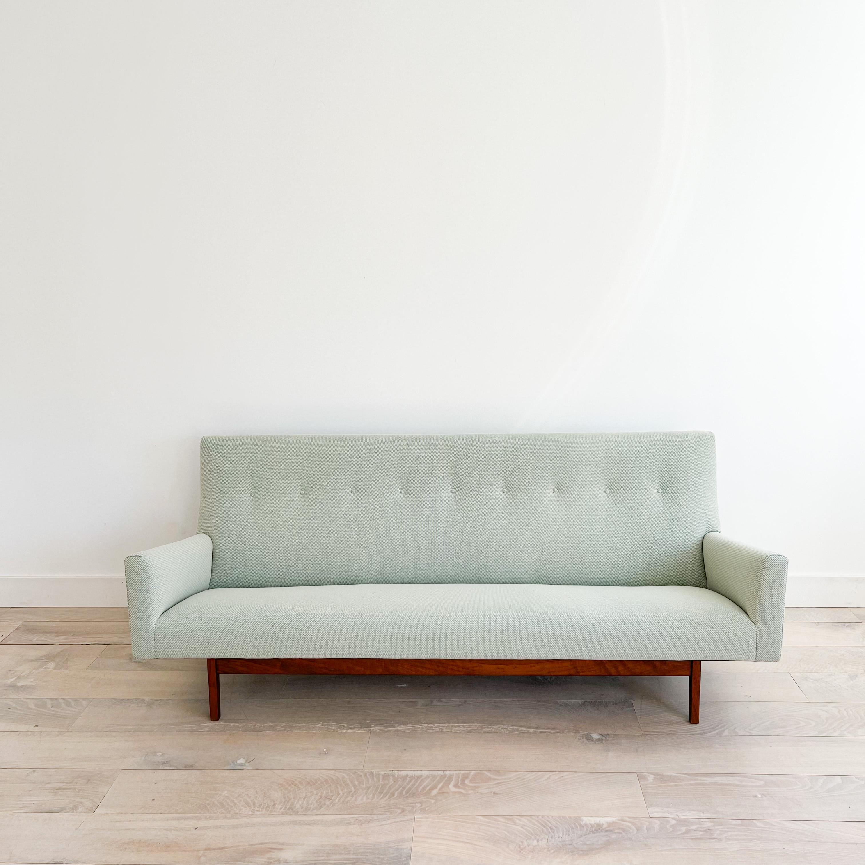 Mid-Century Modern iconic “floating” U150 sofa with a walnut frame designed by Jens Risom. New foam and light mint green upholstery. Some light scuffing/scratching to the walnut frame from age appropriate wear (see up close photos for examples).