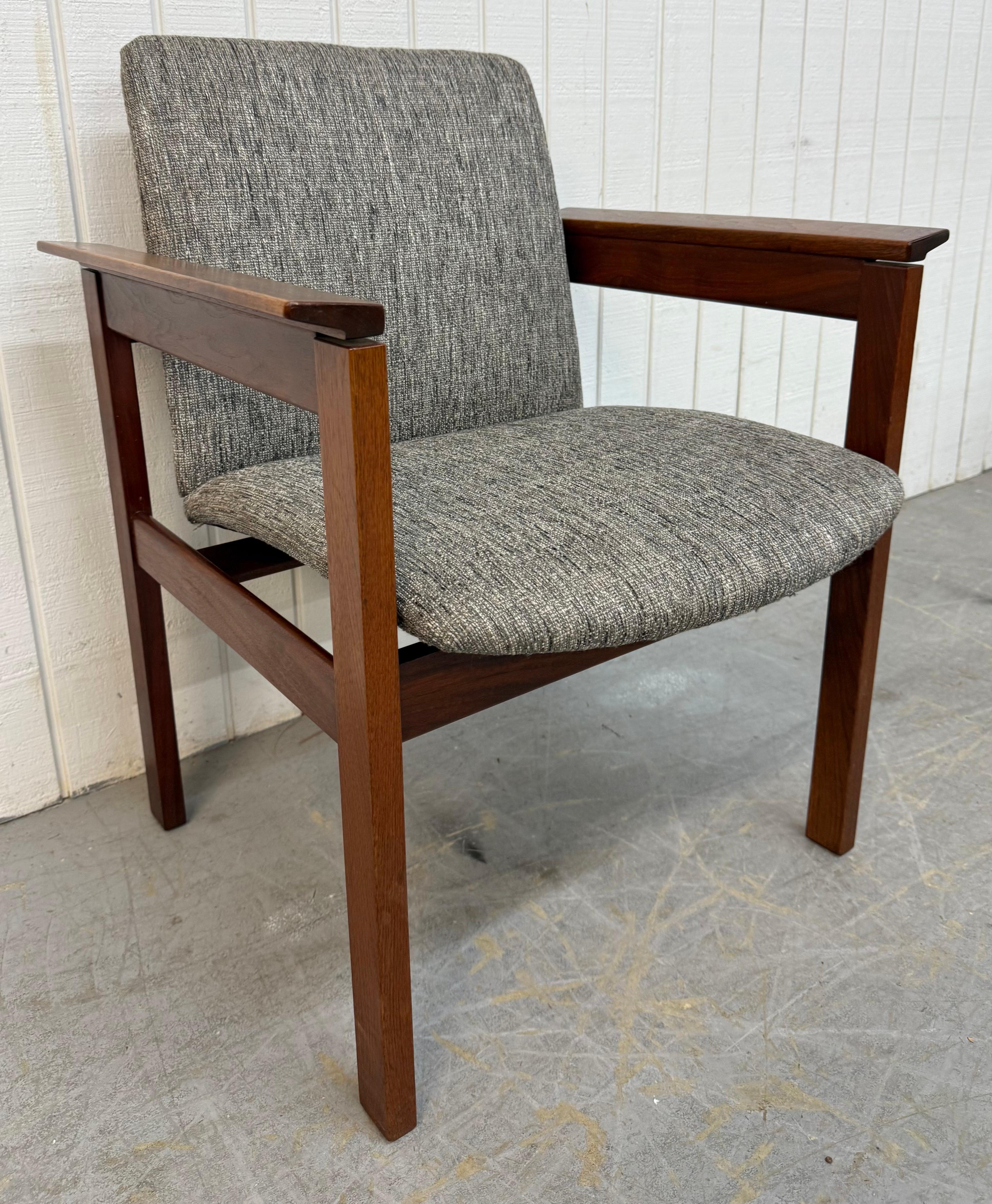 This listing is for a Mid-Century Modern Jens Risom Upholstered Walnut Arm Chair. Featuring a straight line design, wooden frame with slanted arms, new gray upholstery, and a beautiful walnut finish. This is an exceptional combination of quality and