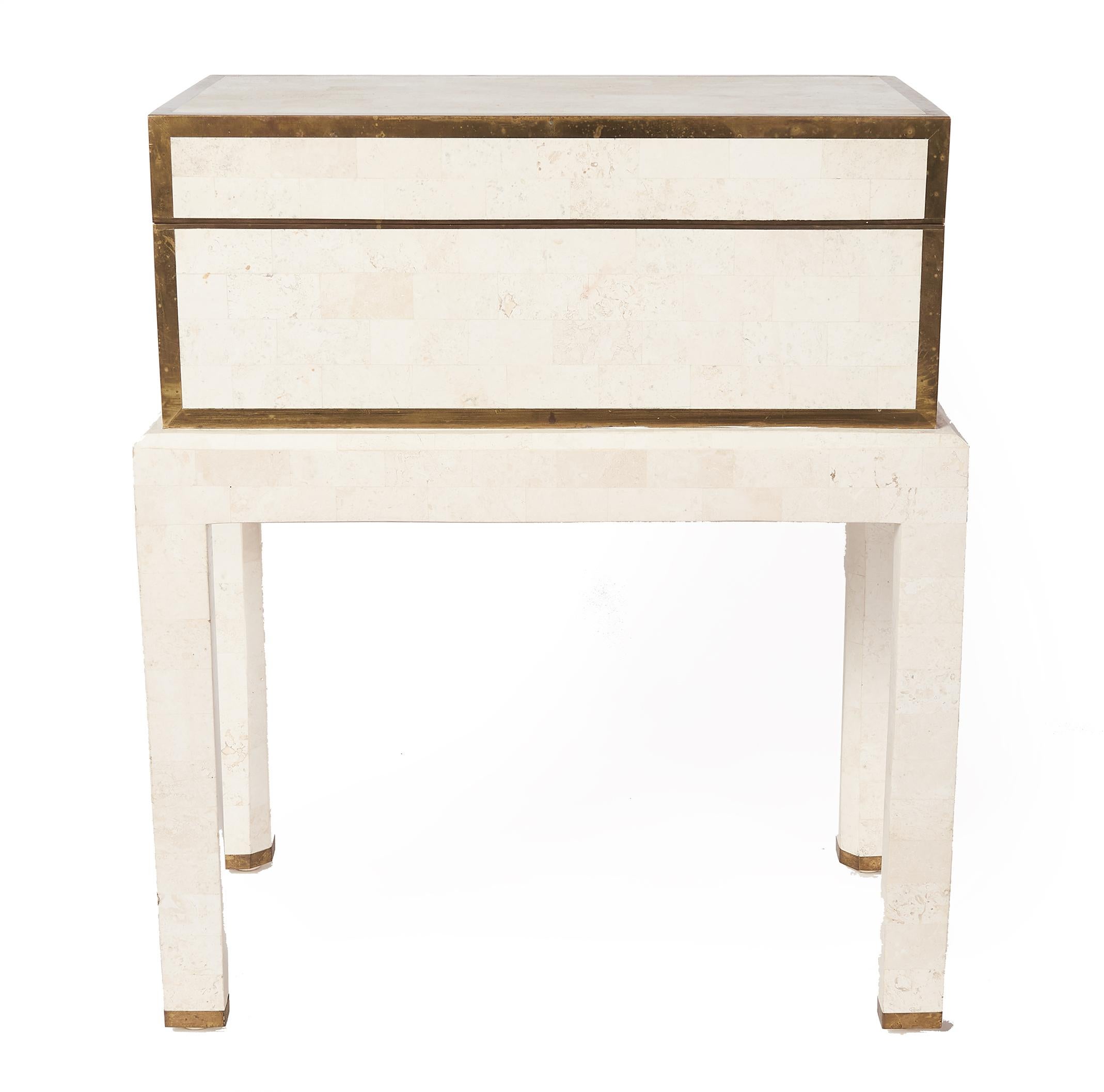 Elegant Mid-Century Modern box by Maitland-Smith is made of white tessellated stone with brass inlay around the edges. The stylishly designed box sits on top of four legs offering convenient access. The unique design has a top that opens up to a