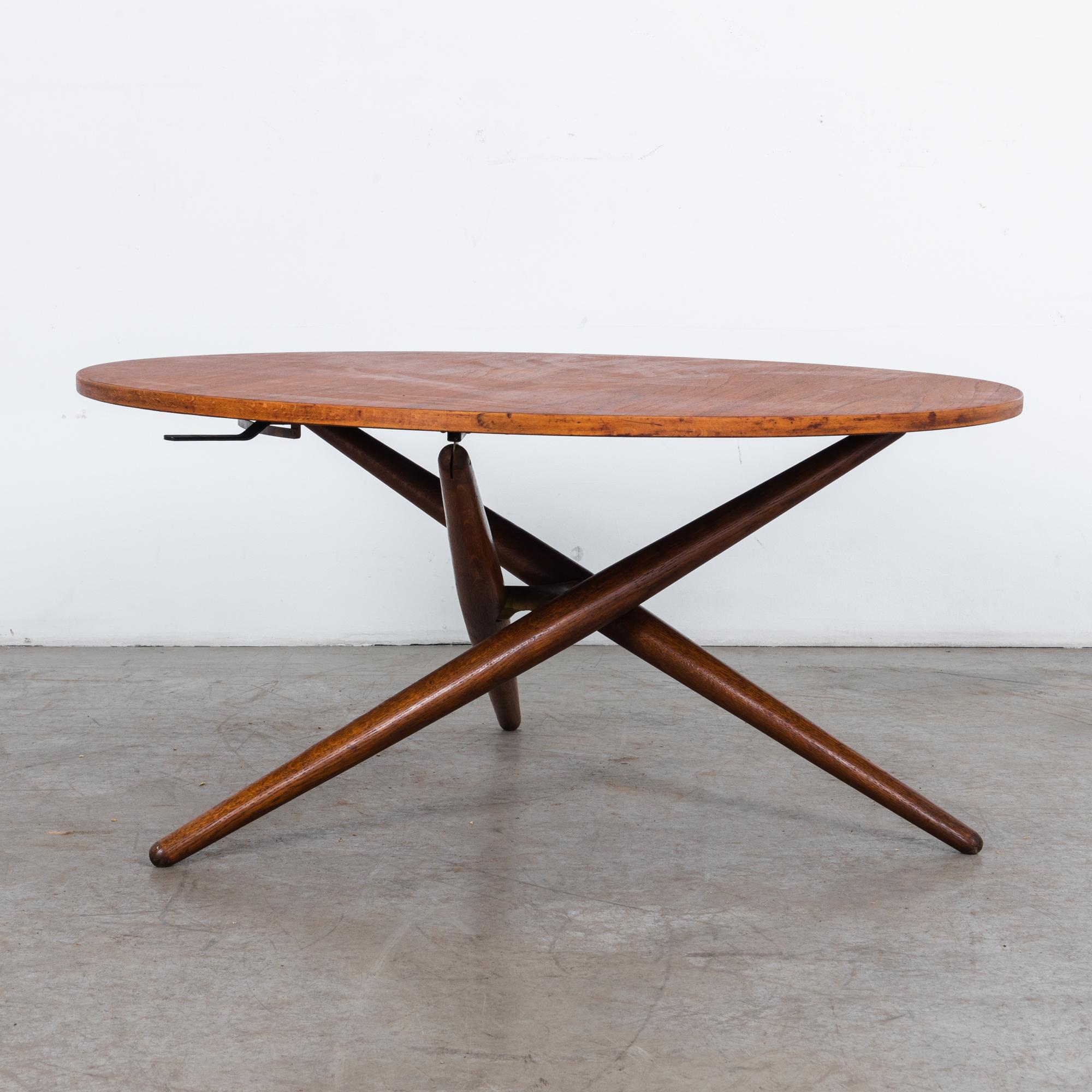 Round adjustable oak wood table with veneered top, by designer Jurg Bally, circa 1960. This acclaimed design features a unique height adjustment mechanism, which while providing an important function is a beautiful detail in itself. This rare